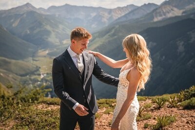 Clemmie rests a hand on Tucker's shoulder as they look at each other above the valley.