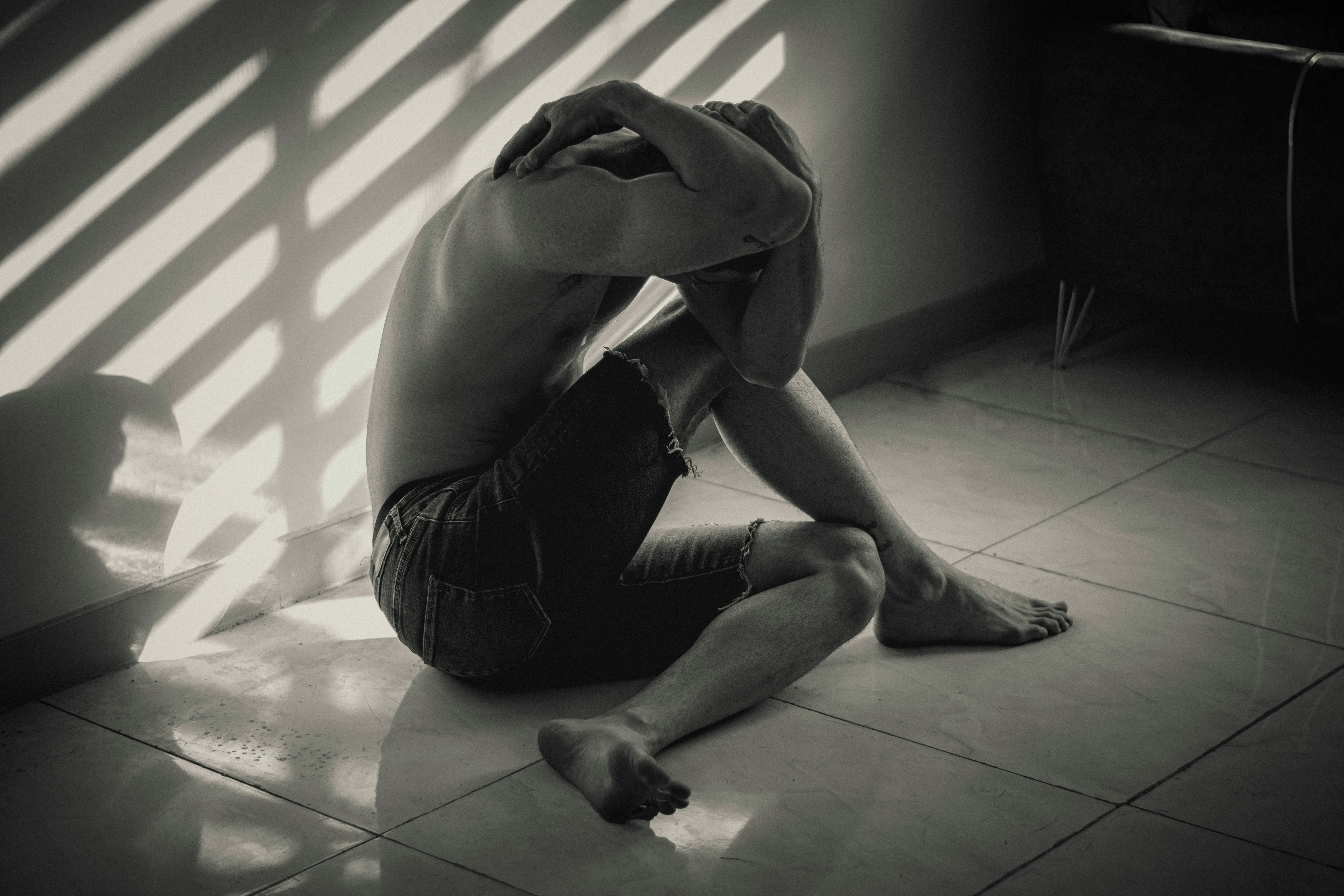 a man sitting on the floor in front of a window