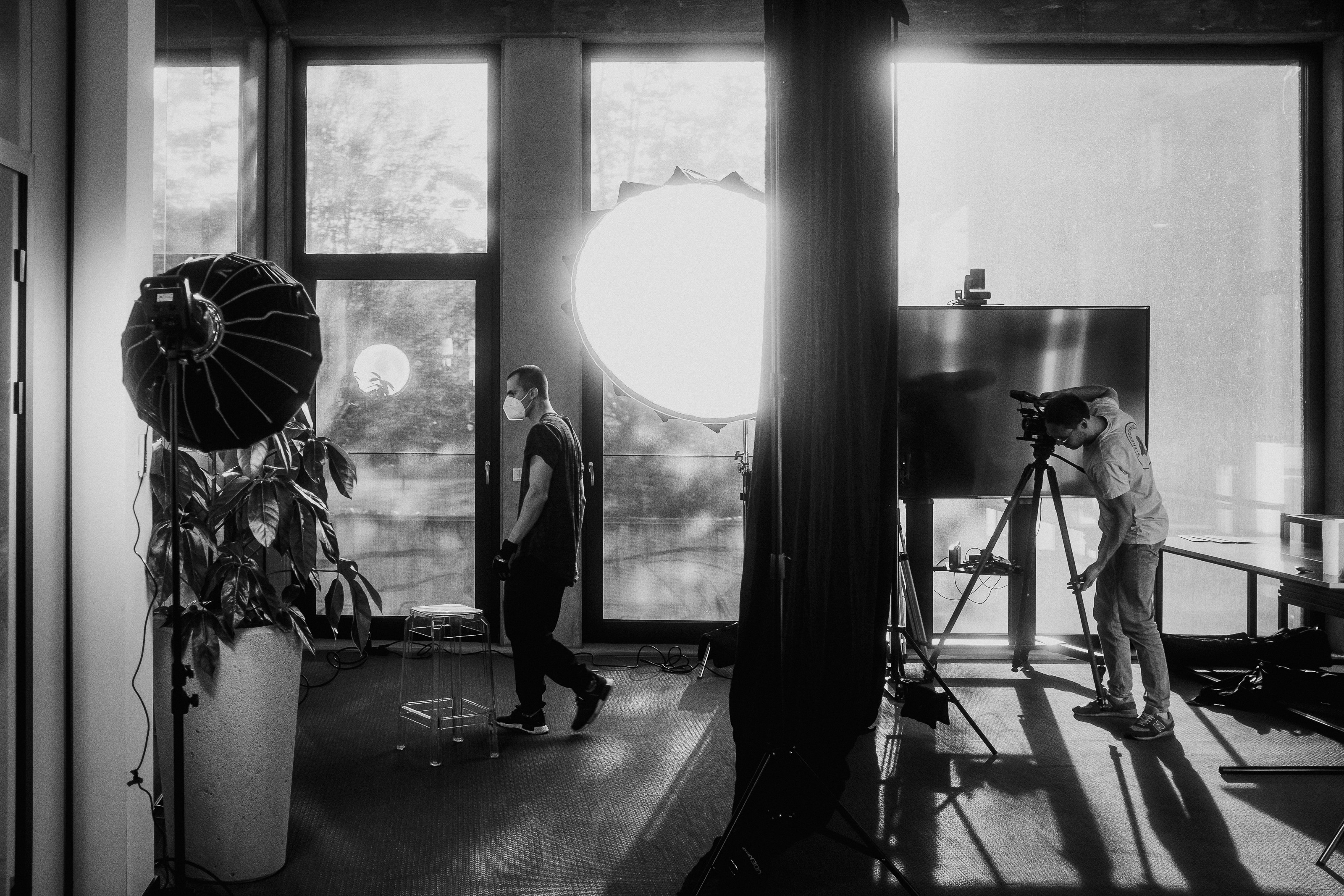 Black and white image of people working at a table with laptops, showing hands gesturing during discussion of digital content displayed on screens, with fabrica® logo in the corner.