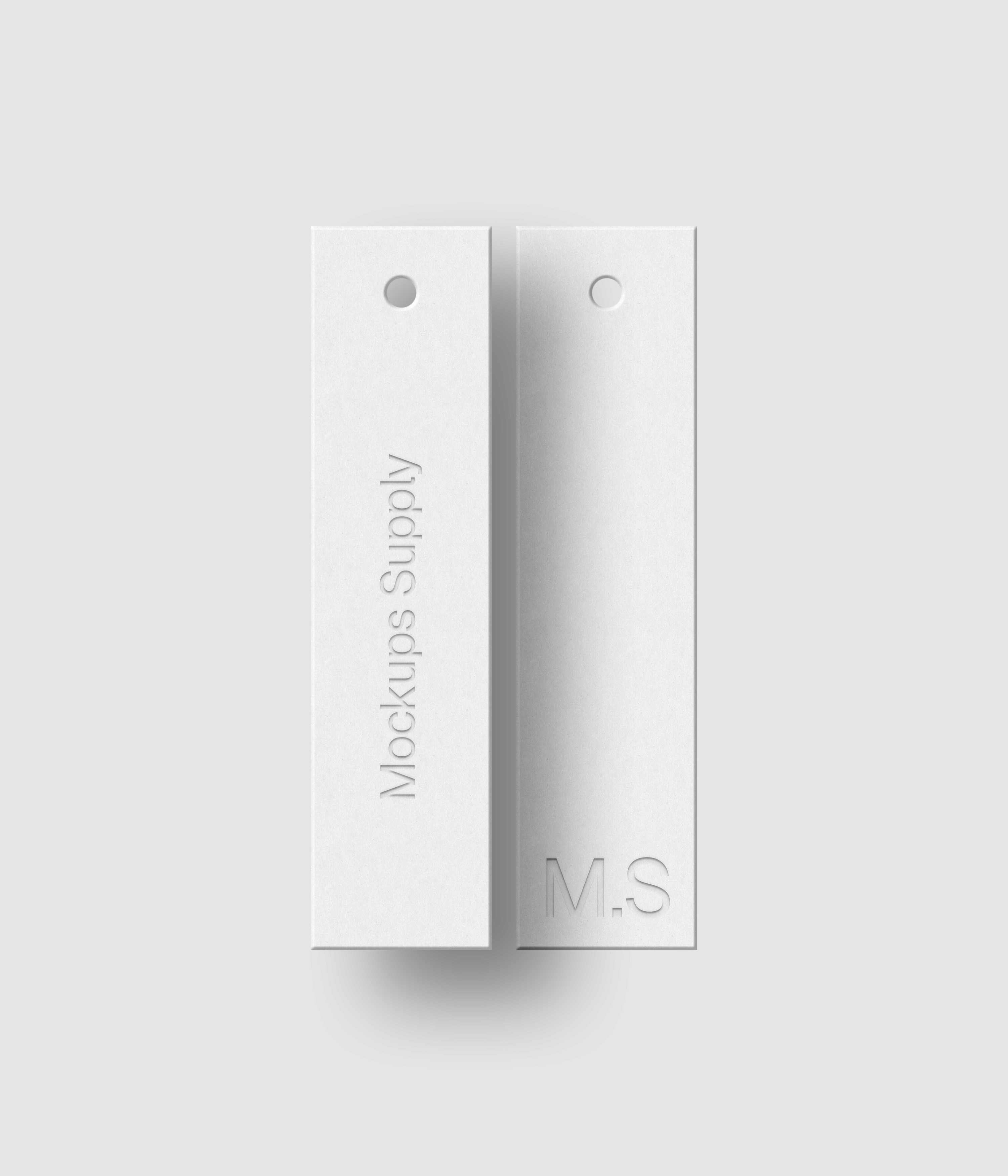 Two white 1x4 slim hang tags mockup on white background with soft shadow and debossed text effect for Photoshop download psd