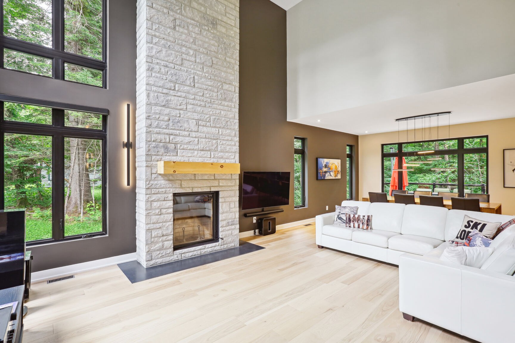 Mur de foyer en pierre et vue sur la salle à manger.