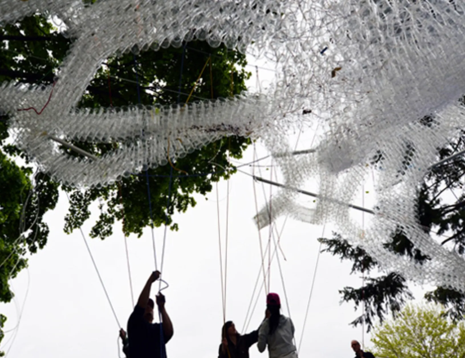 Installation pulley system with volunteers to elevate plastic cup ribbons