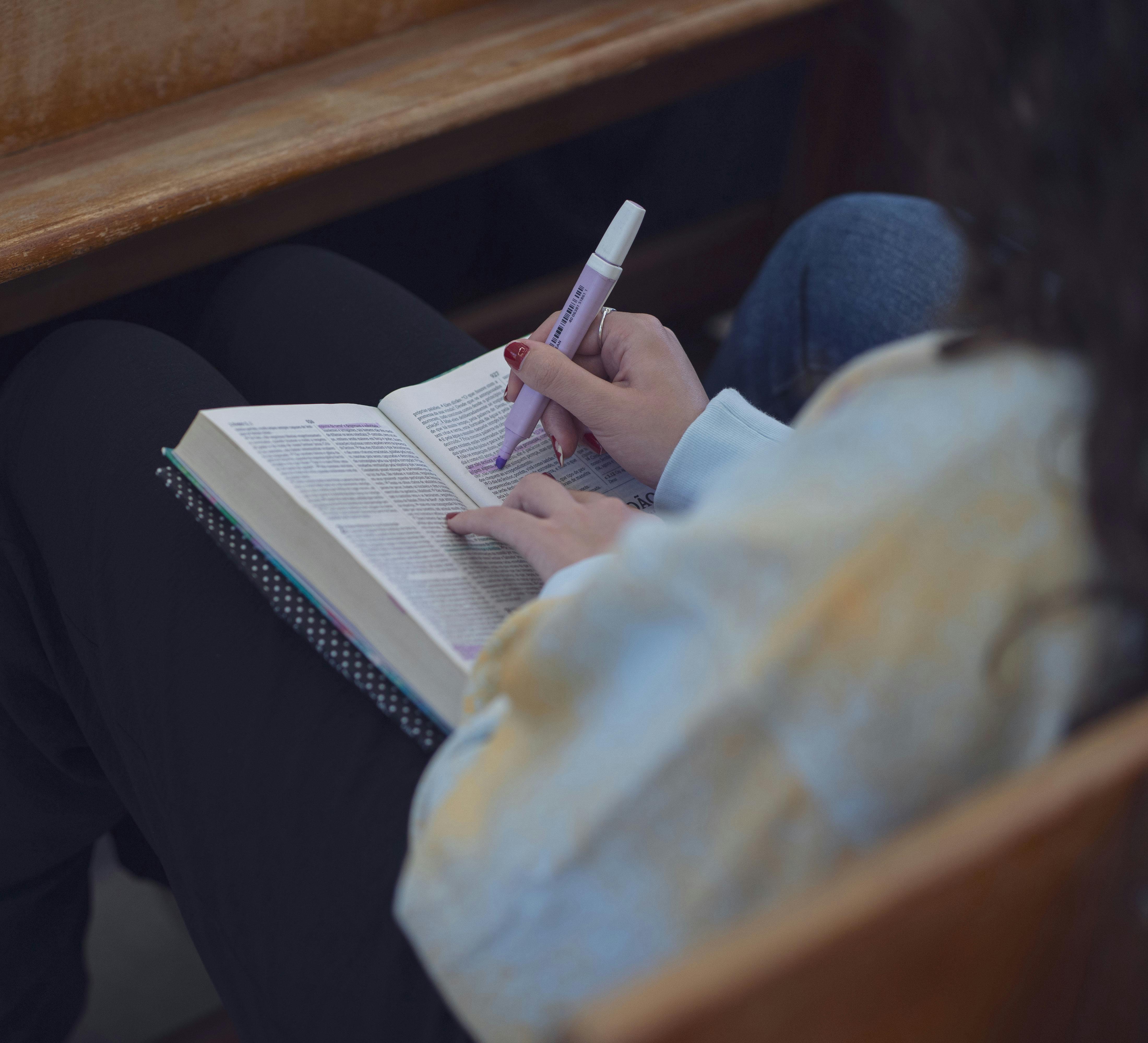 Person Highlighting Text in an Open Book