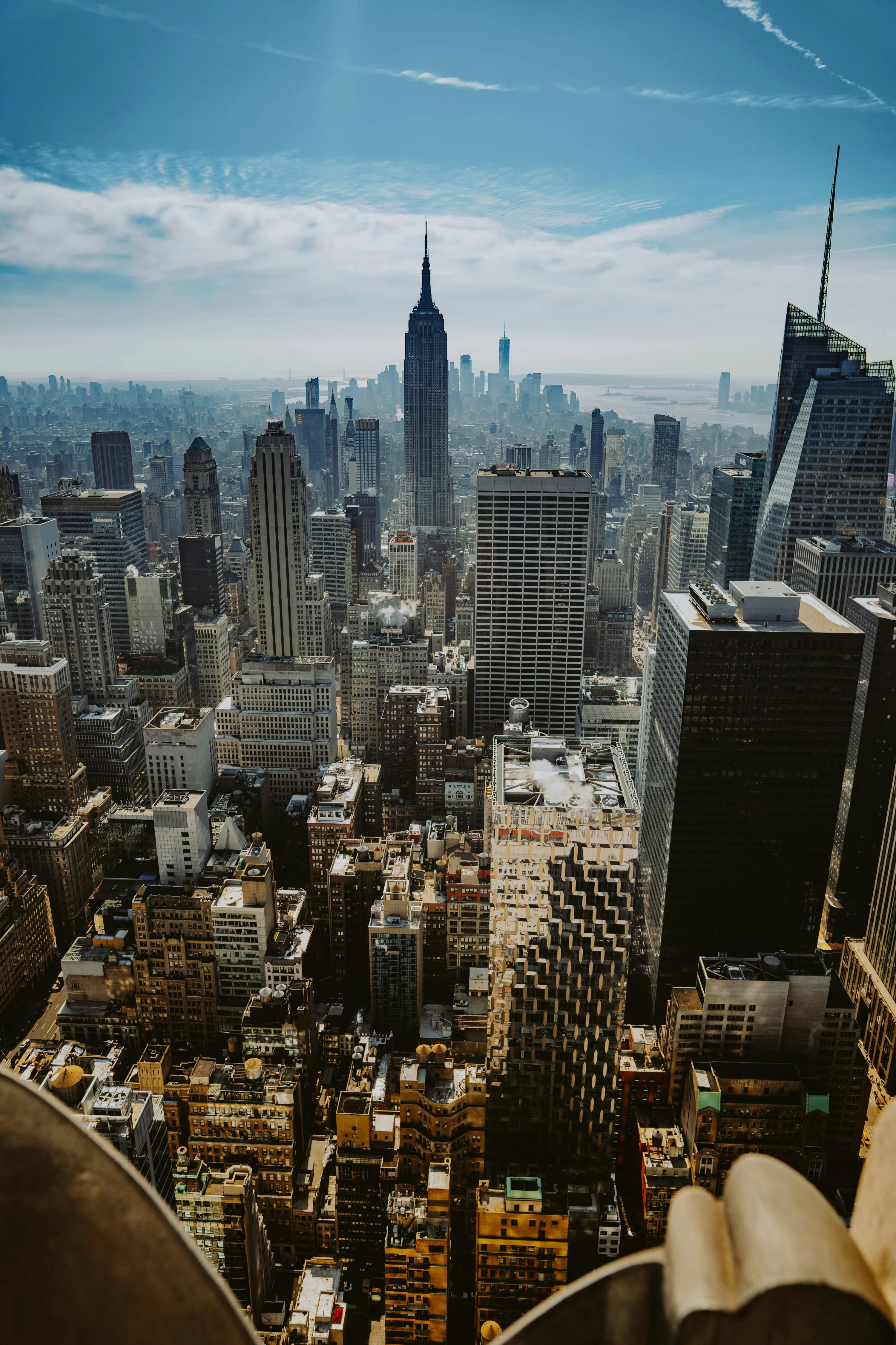 The view from the Top of the Rock at Rockefeller Center in New York City, looking down into the city blocks of Manhattan with the Empire State Building in the distance.