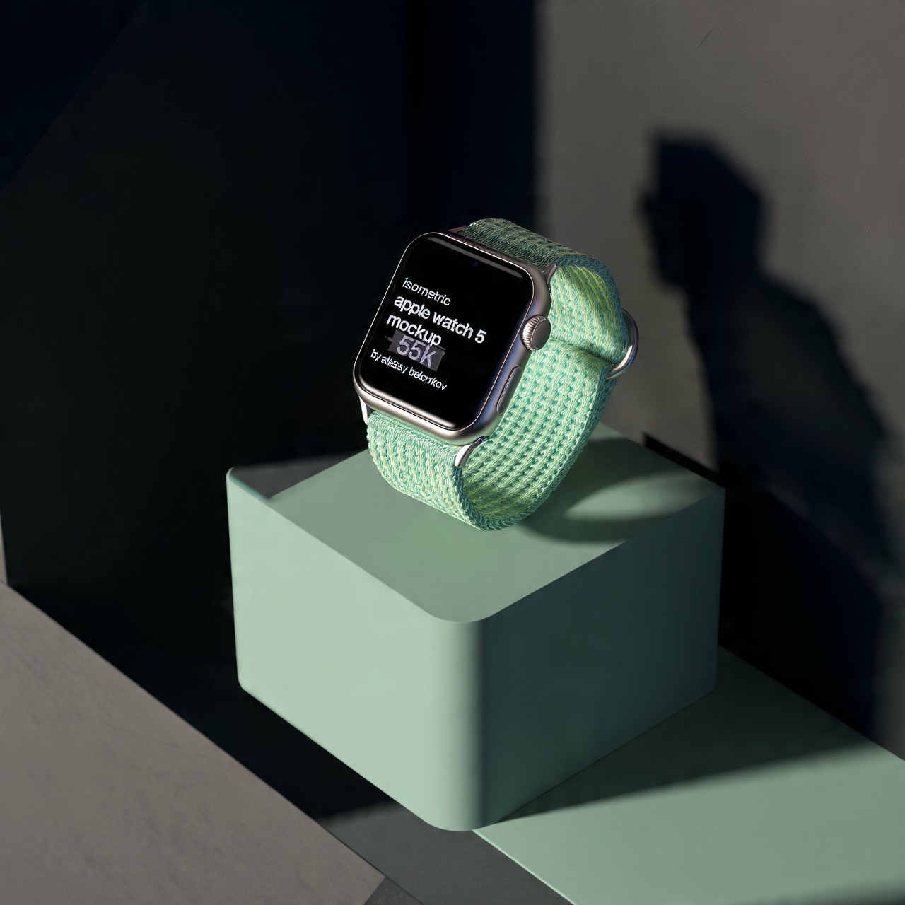Silver Apple Watch 5 with a mint green fabric band resting on a light green cube pedestal.