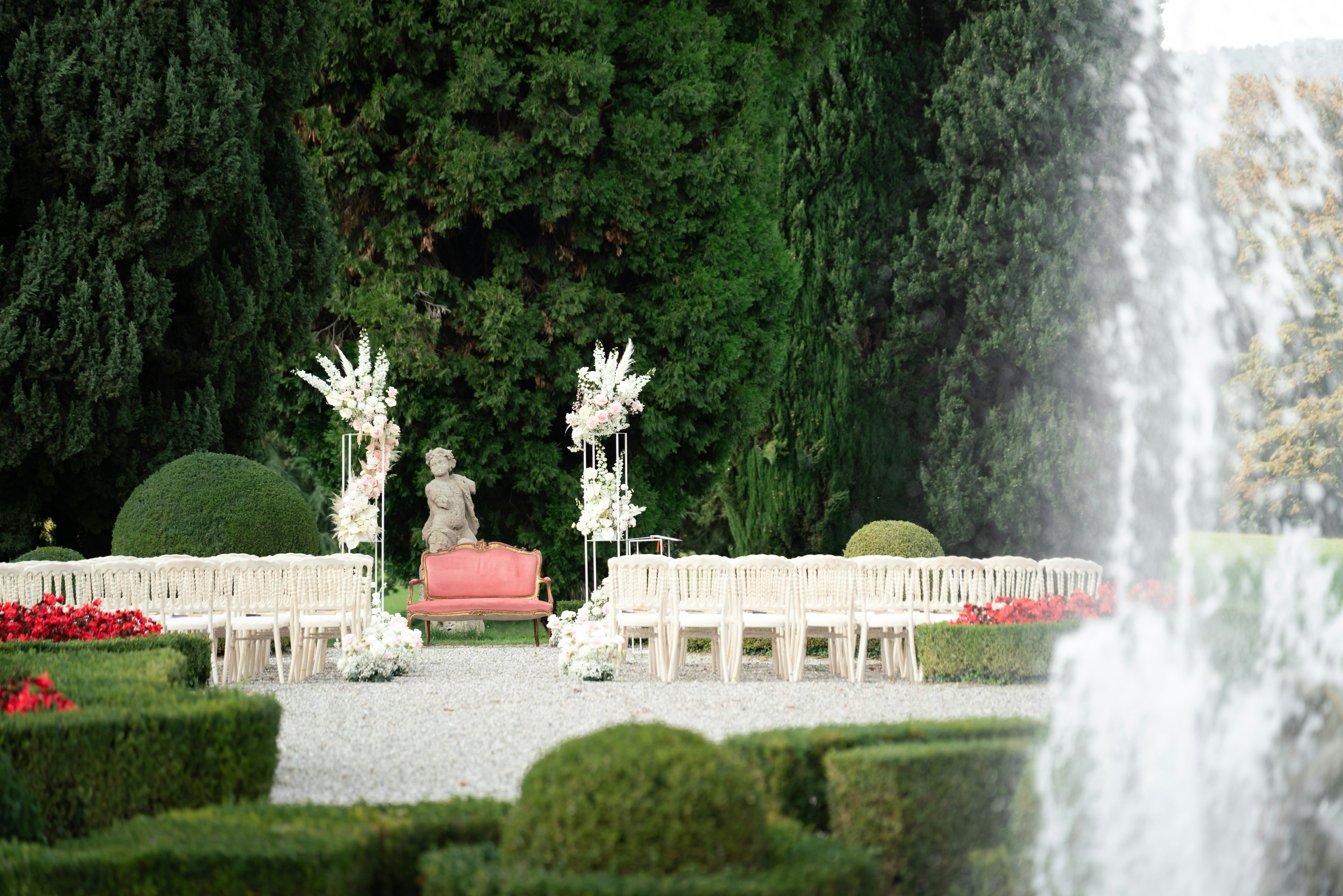 Outdoor wedding ceremony setup with chairs and floral arrangements.