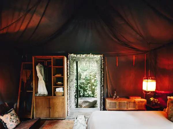 Deluxe Tent at Nômade Tulum highlighting rustic shower, sink, and large mirror with jungle-style decor.