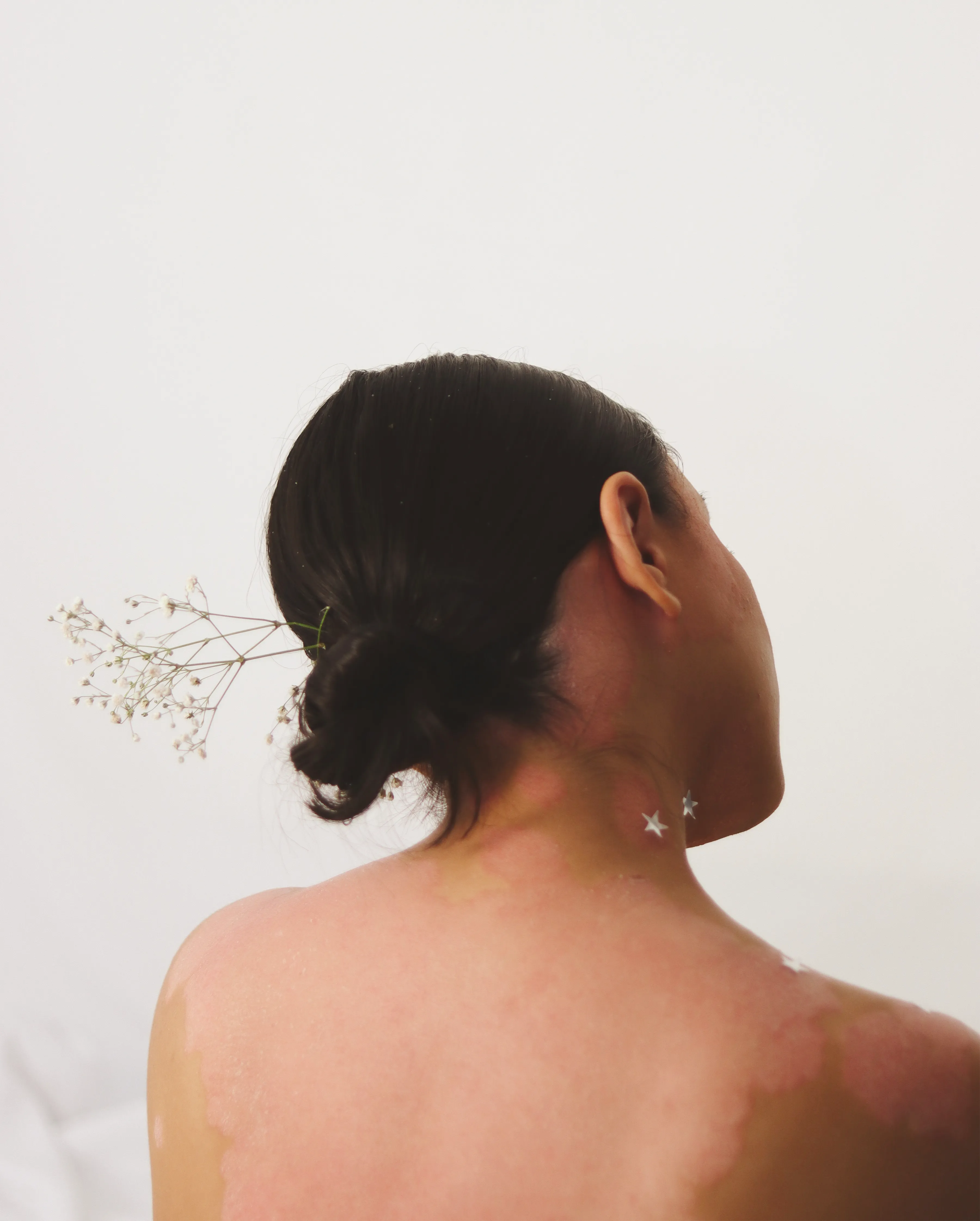 Mujer de espaldas con flores secas en el cabello
