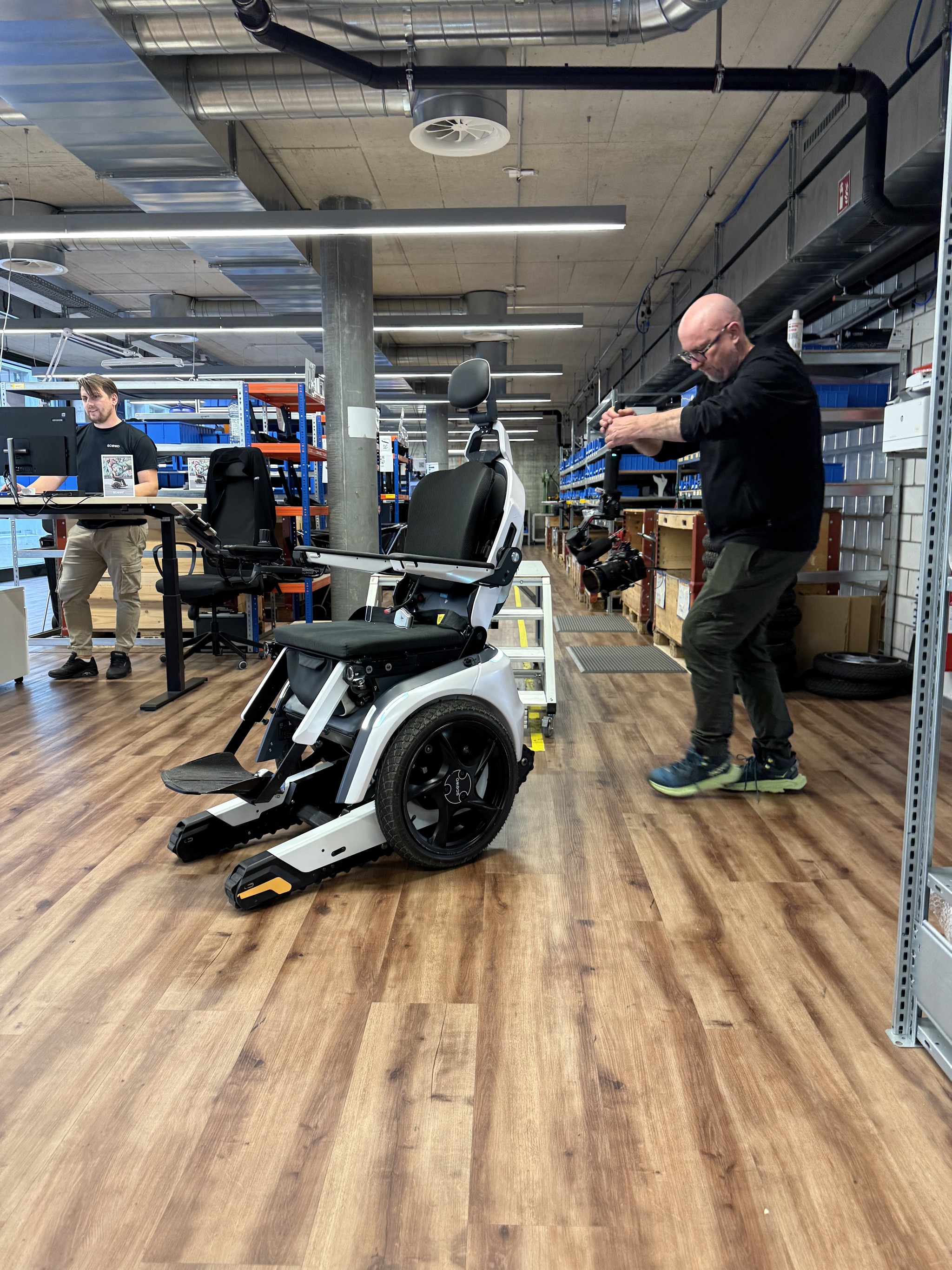 Image of crew shooting B-Roll at Scewo HQ in Switzerland with a white Scewo Bro wheelchair in frame.