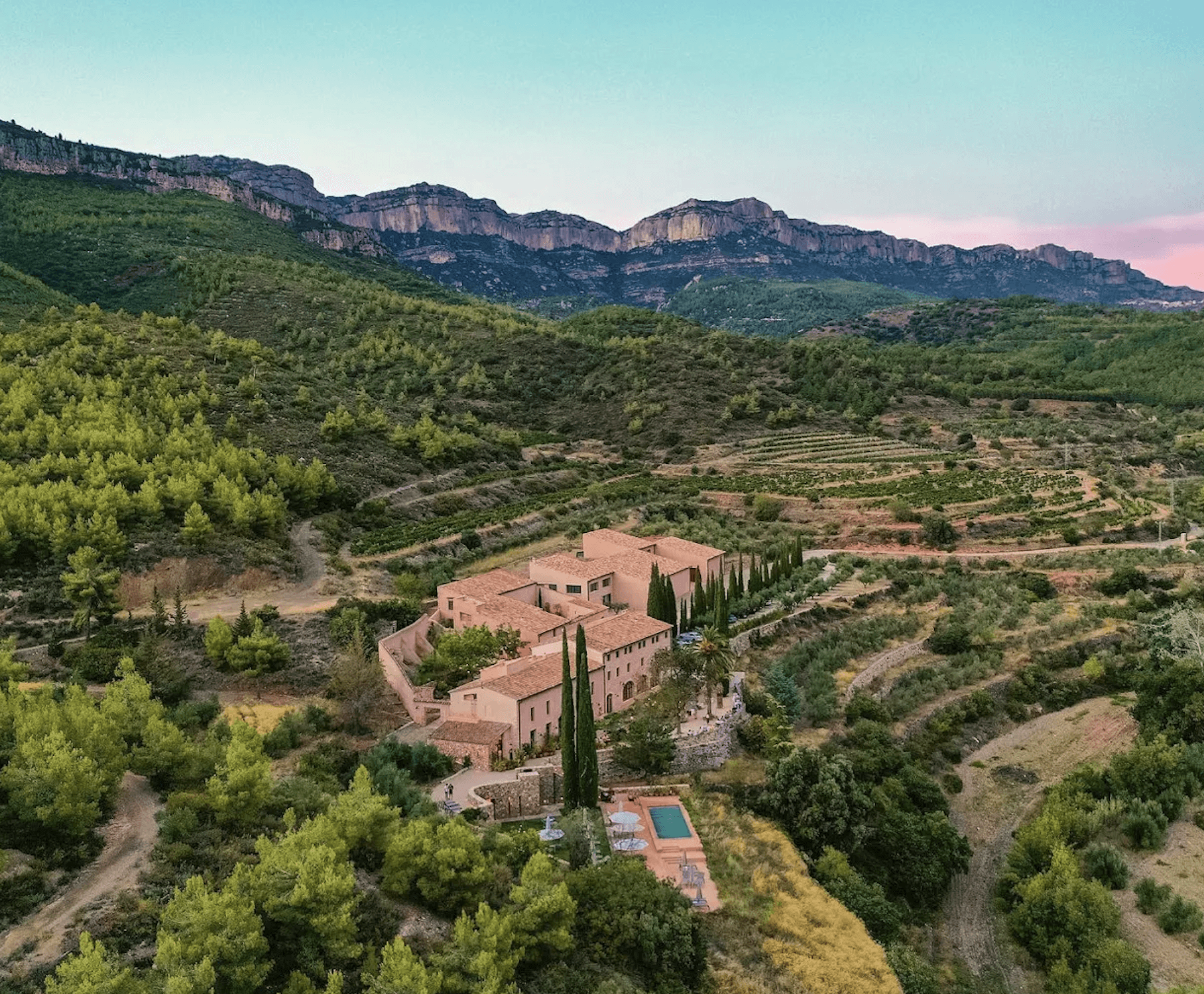 aerial view of a vineyard estate in a valley surrounded by mountains