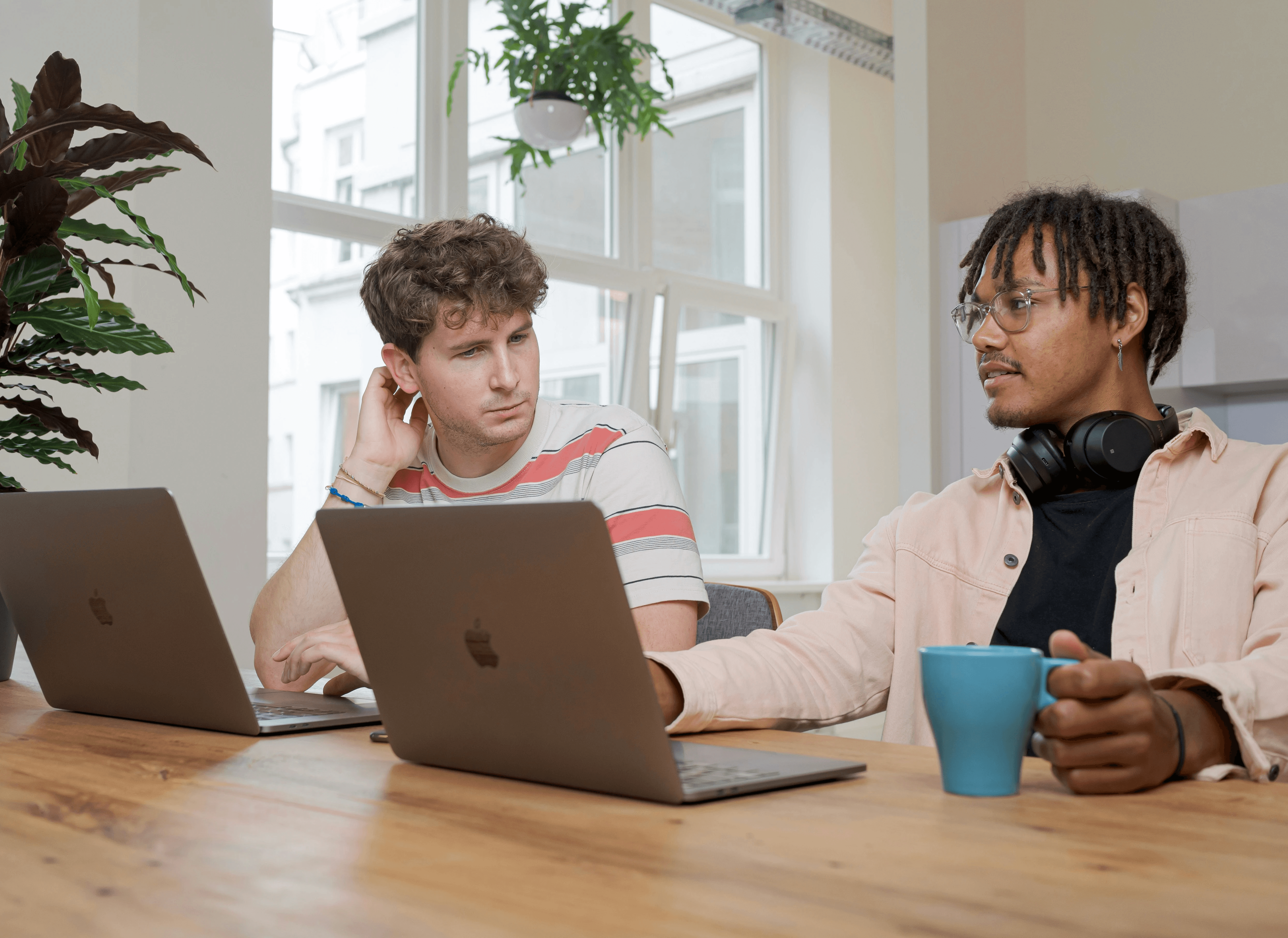 man and woman sitting at table using macbook