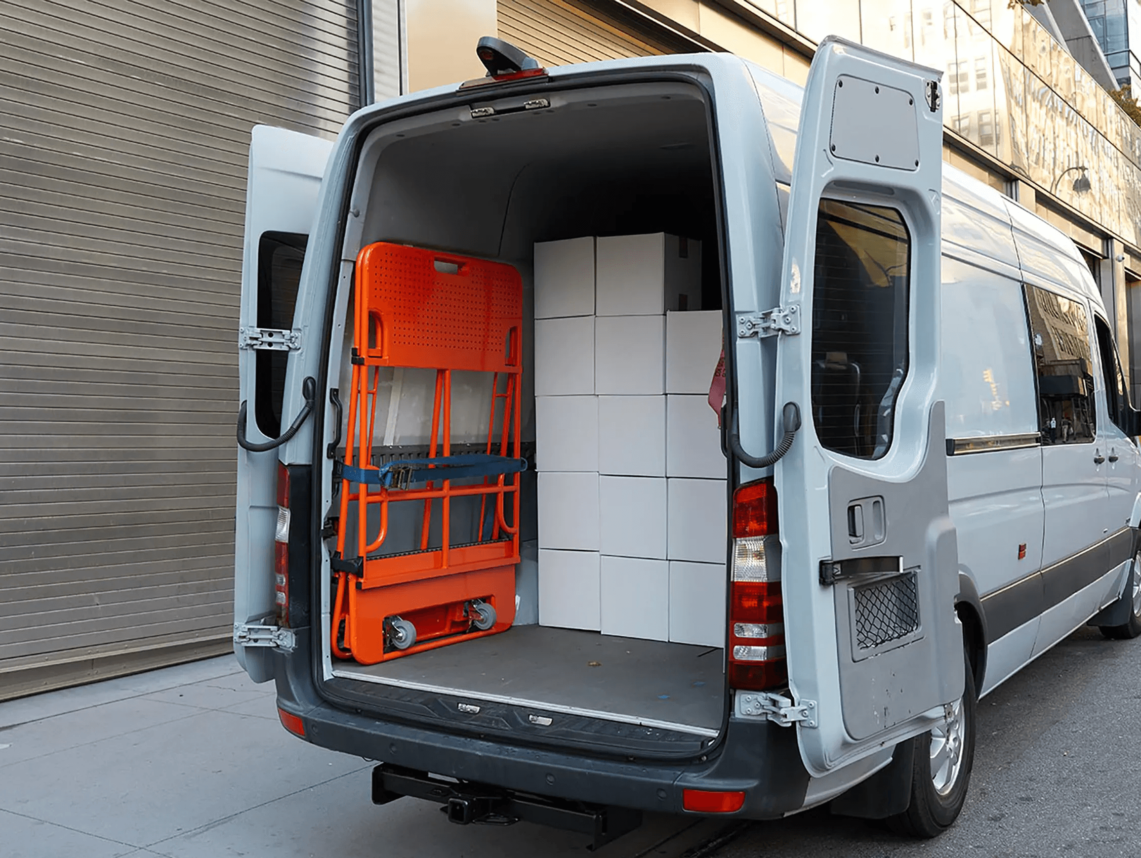 Folded Butterfly Cart stored vertically inside the rear of a work van