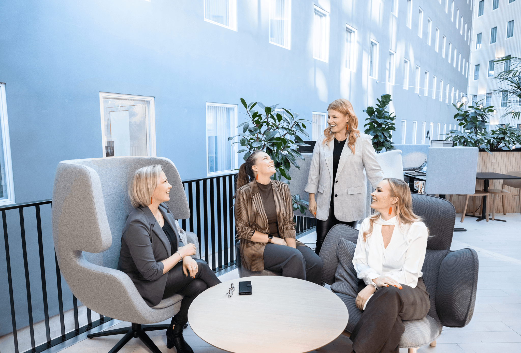 Network & Growthin valmentajatiimi keskustelee modernissa toimistoympäristössä; sparraava ja avoin työpajatunnelma.