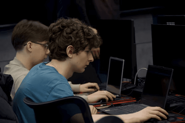 High school student working on a laptop conducting original computer science research with a PhD mentor via video call