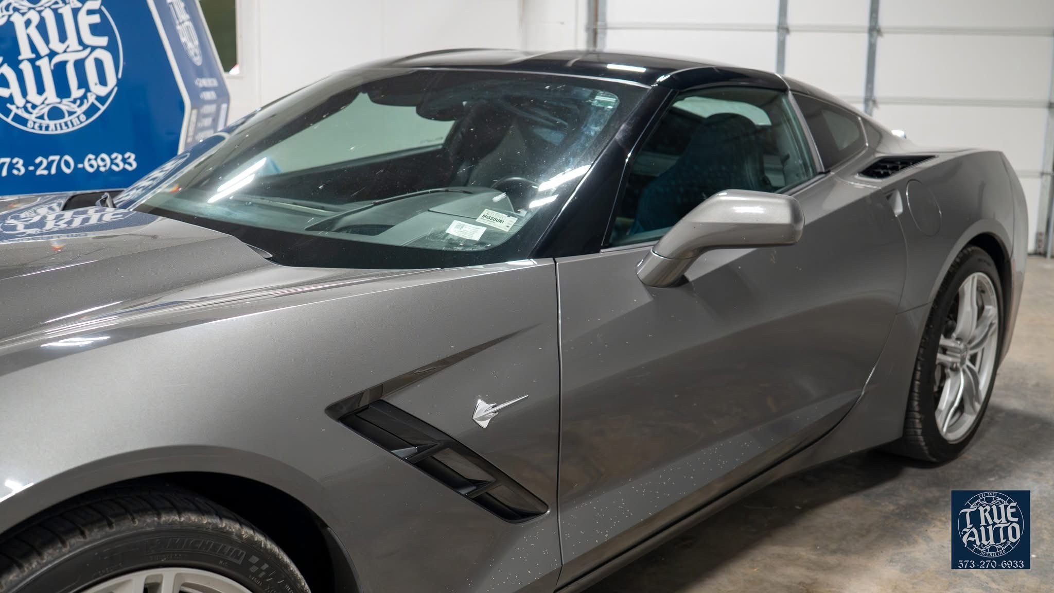 grey car in shop untinted window