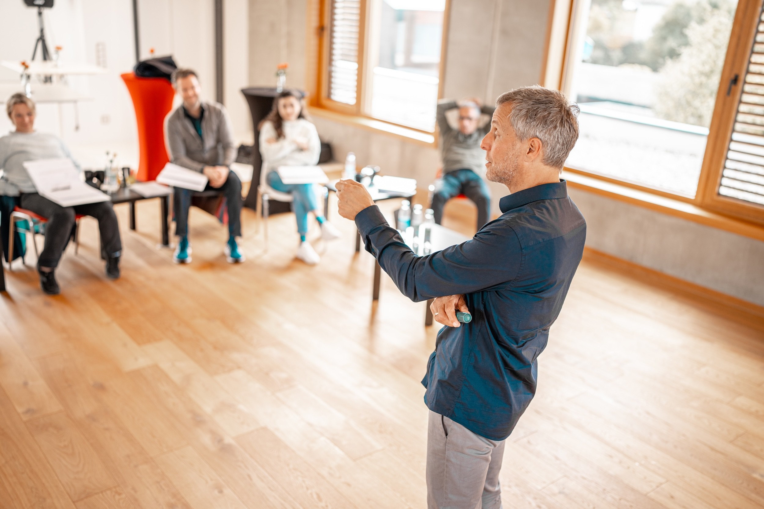 man standing in front of people sitting beside table with laptop computers