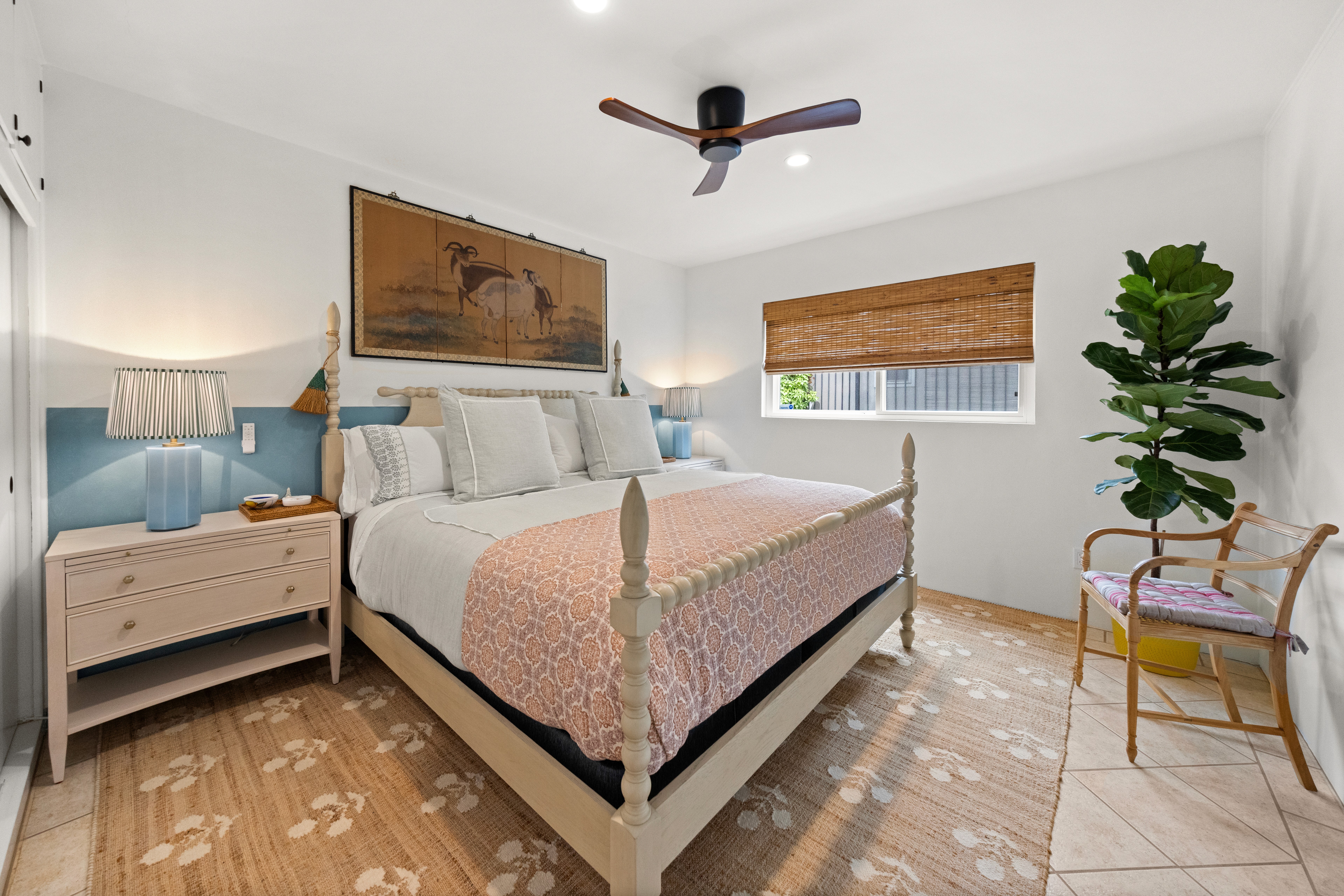 A spacious king bedroom designed for comfort, featuring woven textures, soft linen bedding, and tranquil coastal accents.