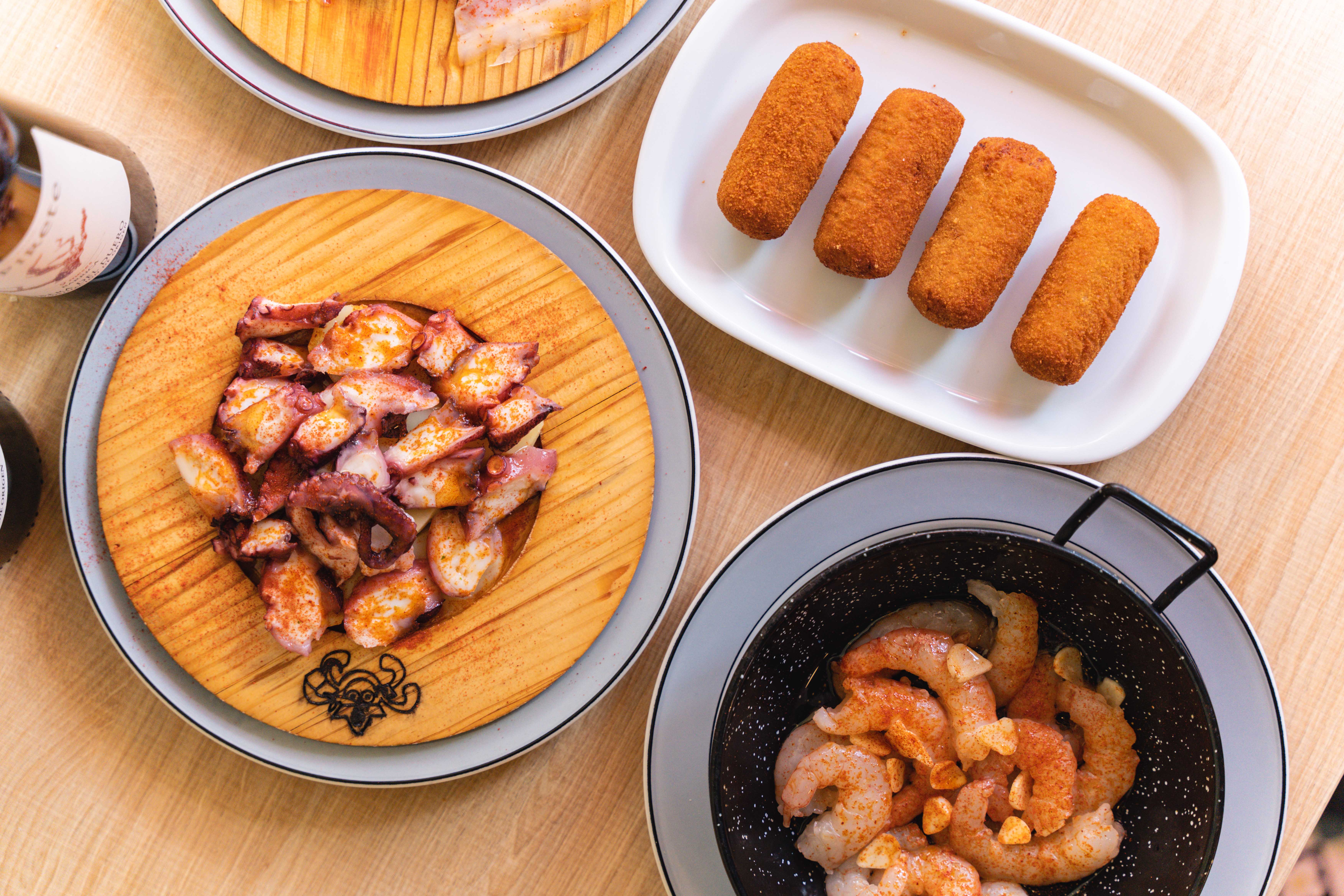 diferentes platos típicos españoles. Croquetas, Gambas al ajillo y pulpo a la gallega