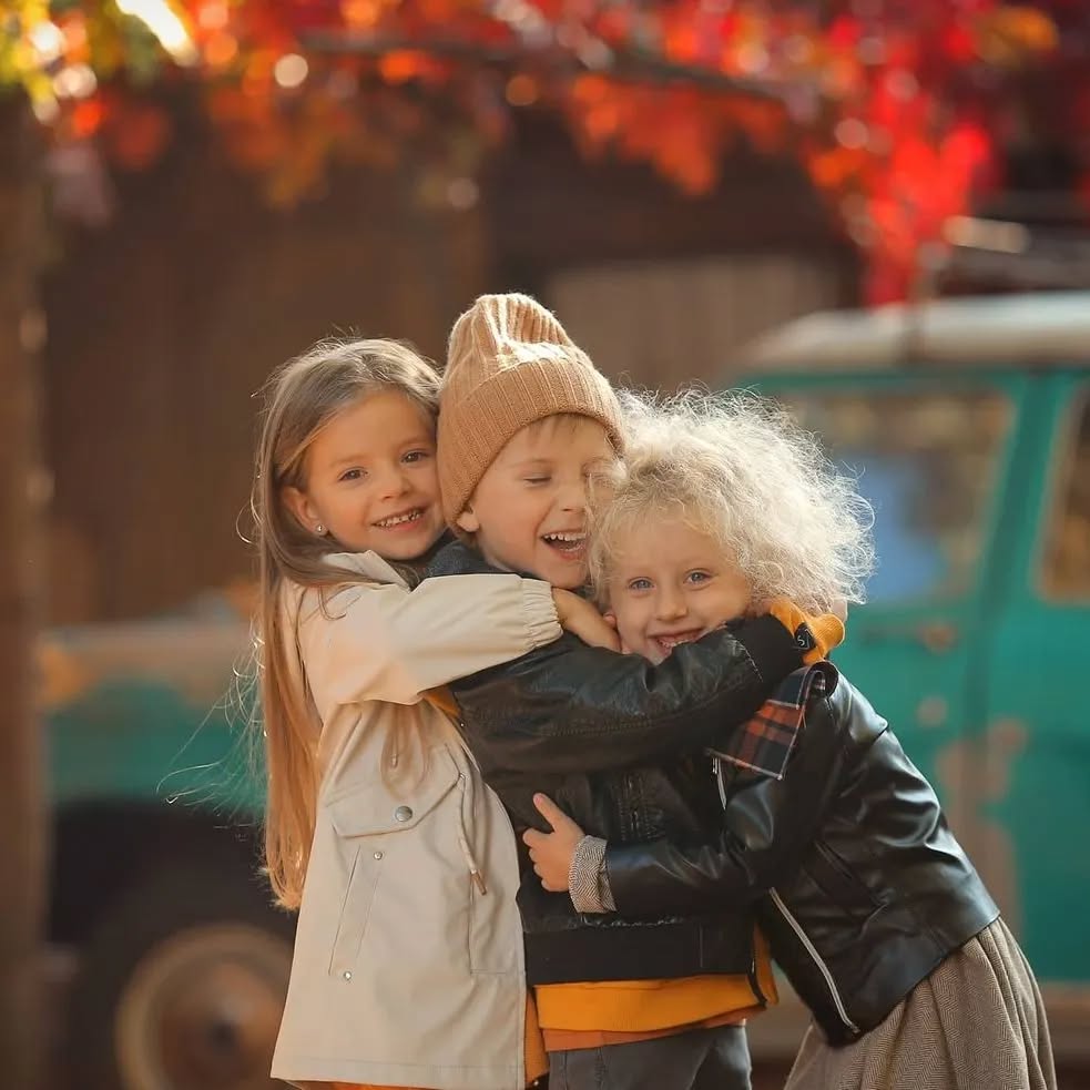 Kids hugging during a warm, playful family photoshoot.