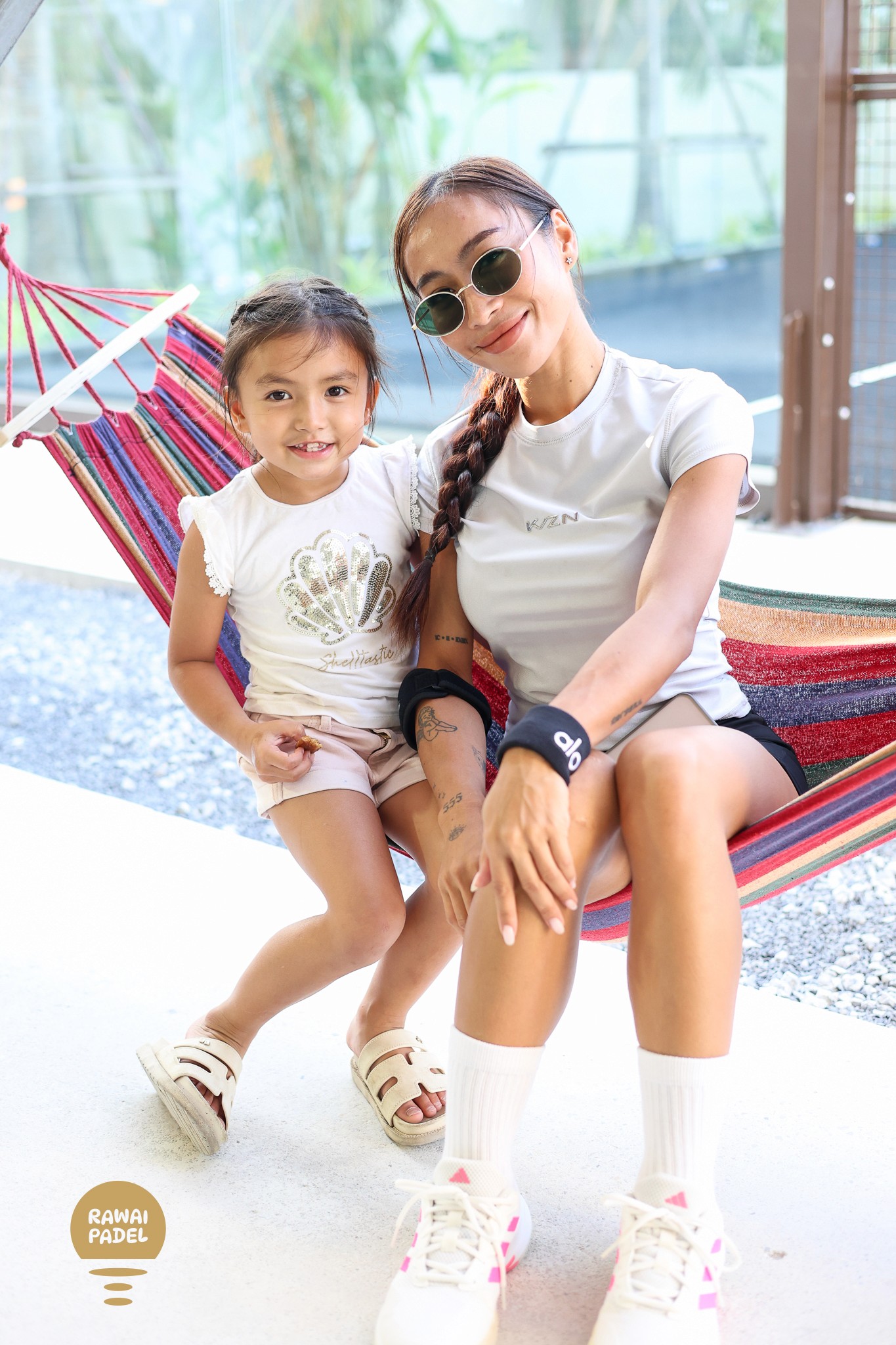 two young women sitting on the ground next to each other