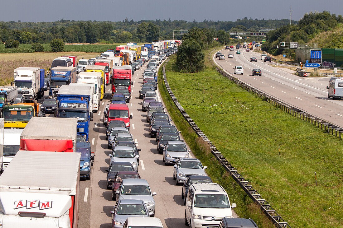 Freight trucks driving on a German highway, representing the impact of increased road tolls on European logistics.