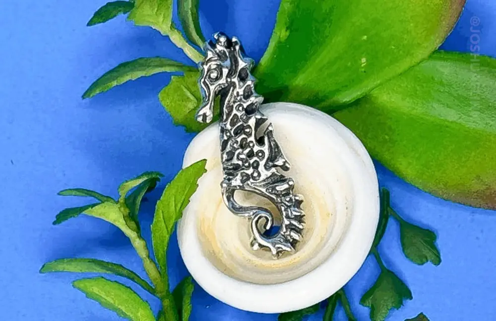 photograph of a cast silver pendant of a polynesian seahorse