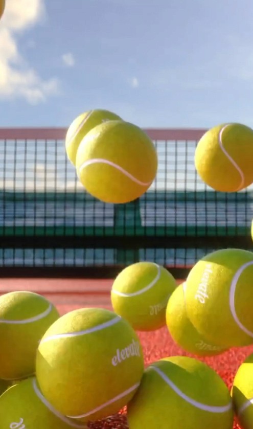 Dynamic 3D-rendered scene of multiple bright yellow tennis balls bouncing on a red court, captured mid-air against a clear blue sky. A high-quality sports animation by 9R Studios, showcasing realistic motion physics, product visualization, and CGI excellence for branding and advertising
