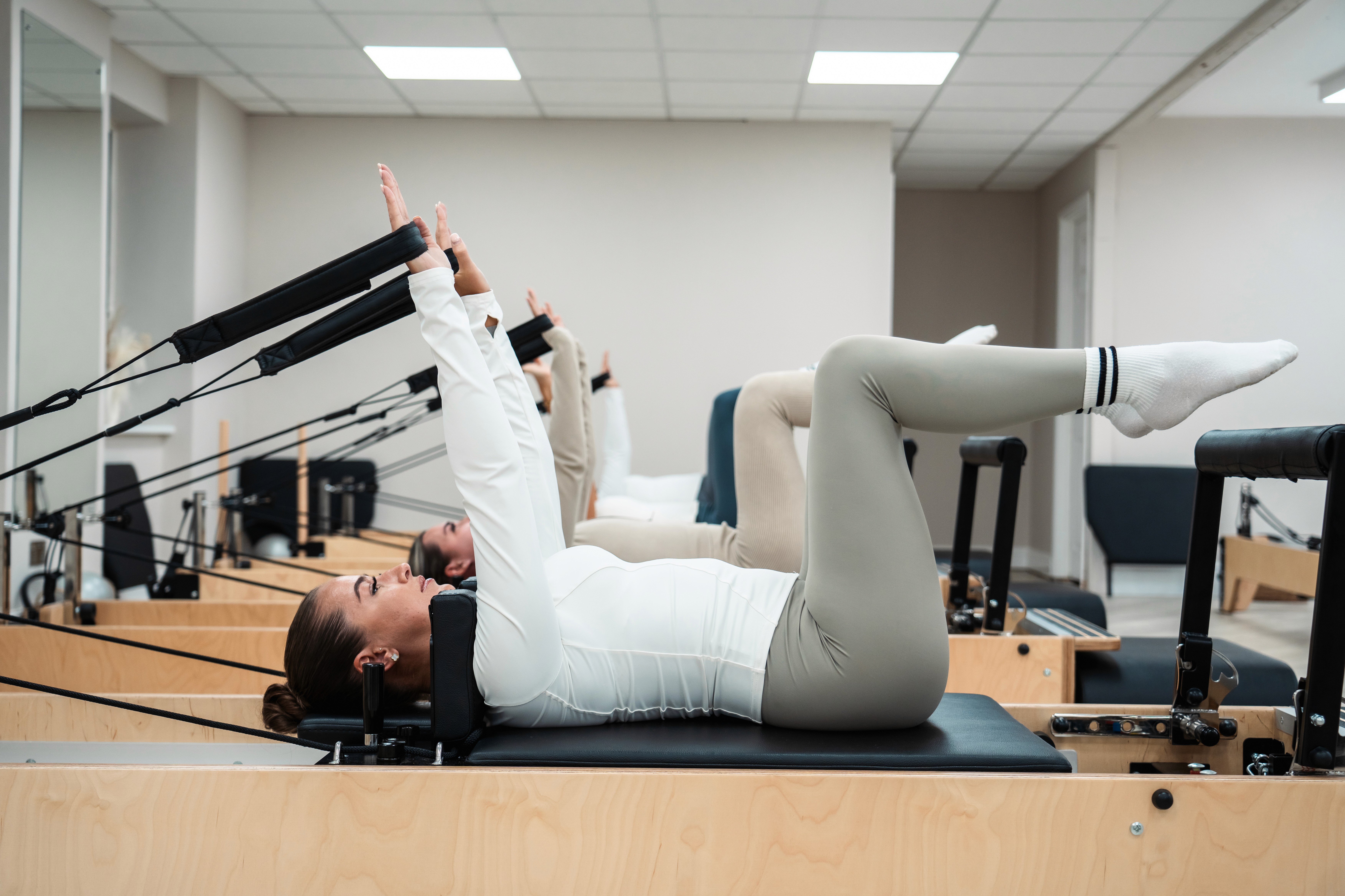 Close up image of clients stretching on the reformer Pilates machine.