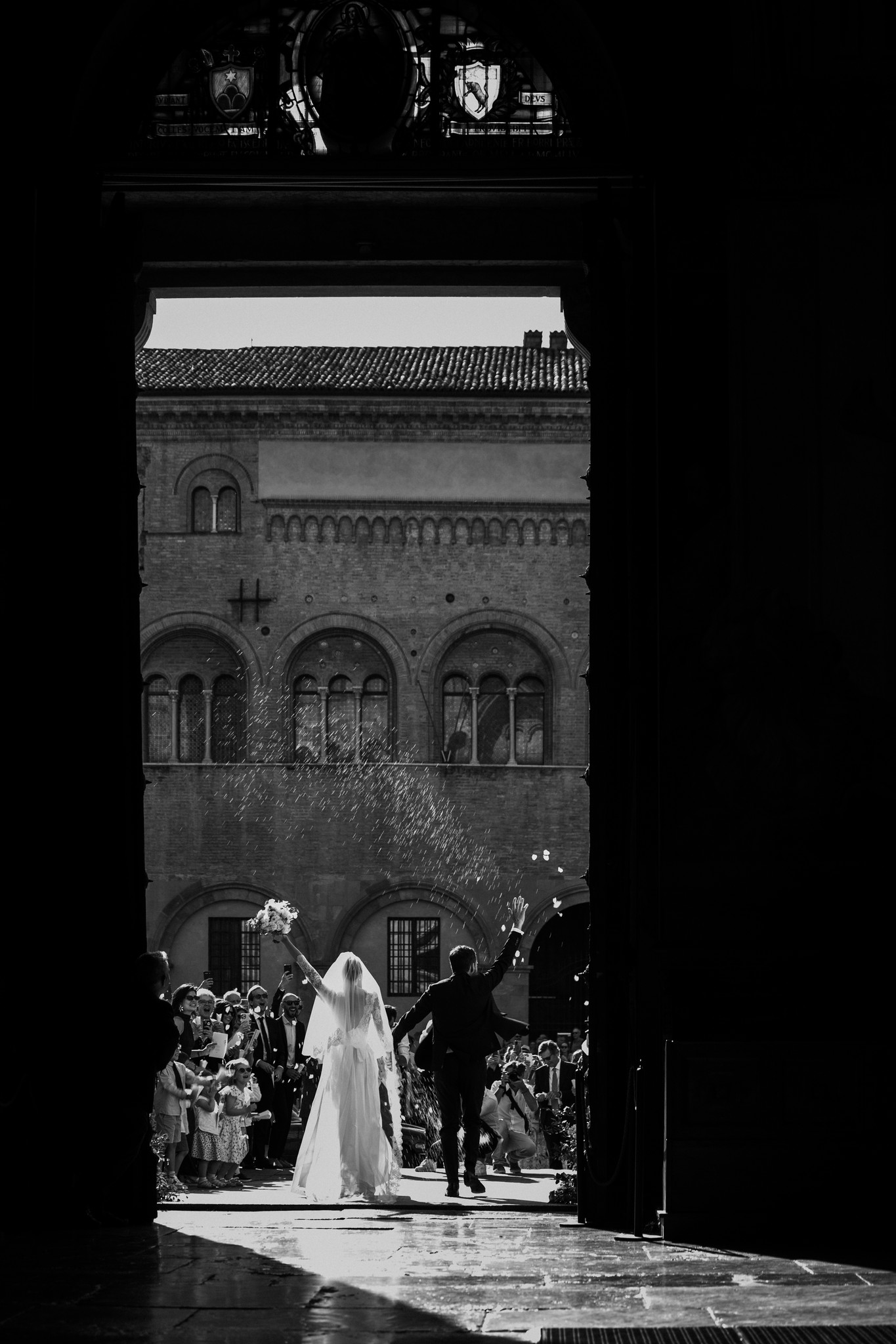 Sposa in abito bianco all'ingresso della villa, luce naturale incornicia la facciata, reportage matrimonio Fotolize