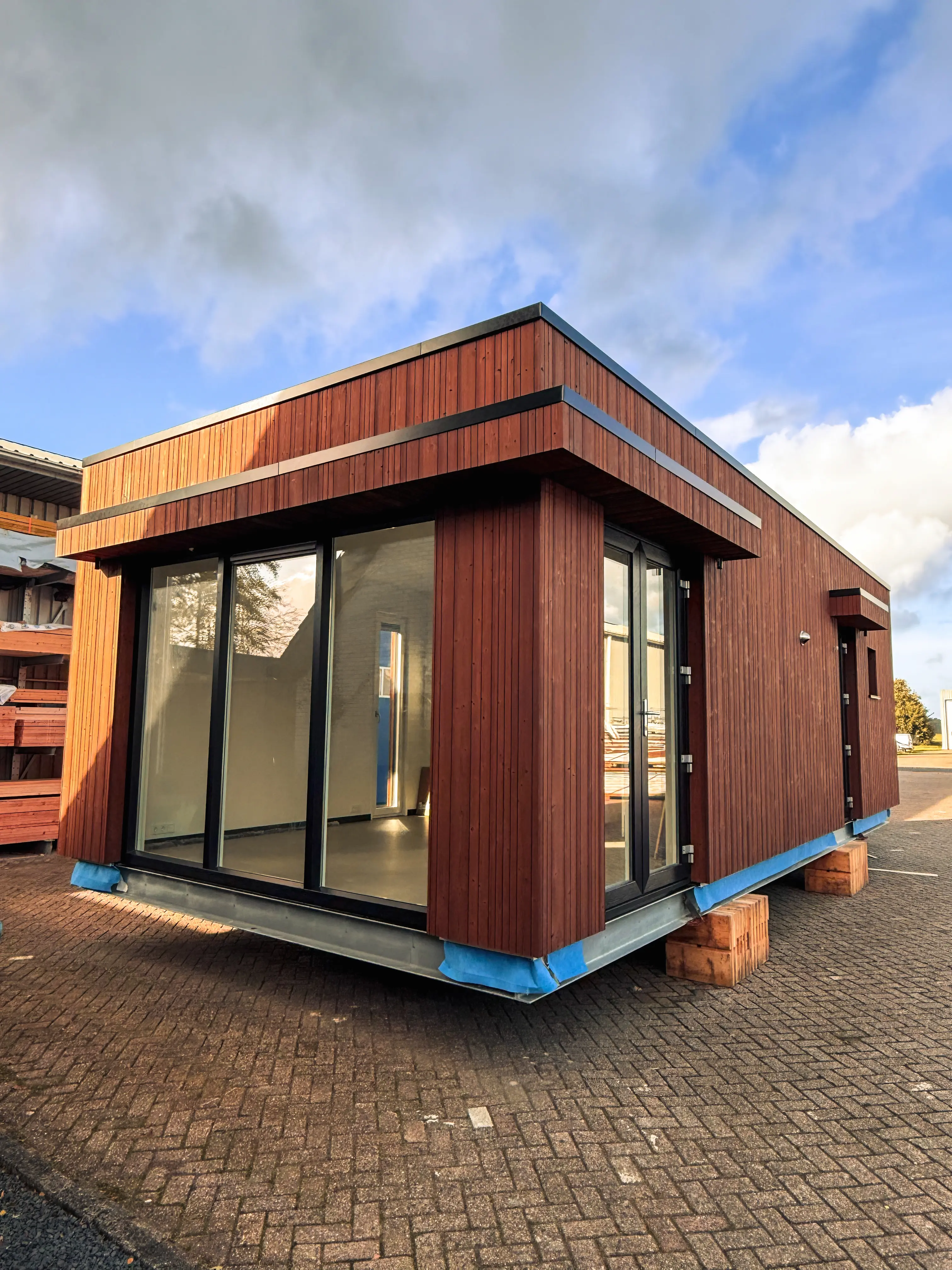 a wooden walkway between two buildings with windows