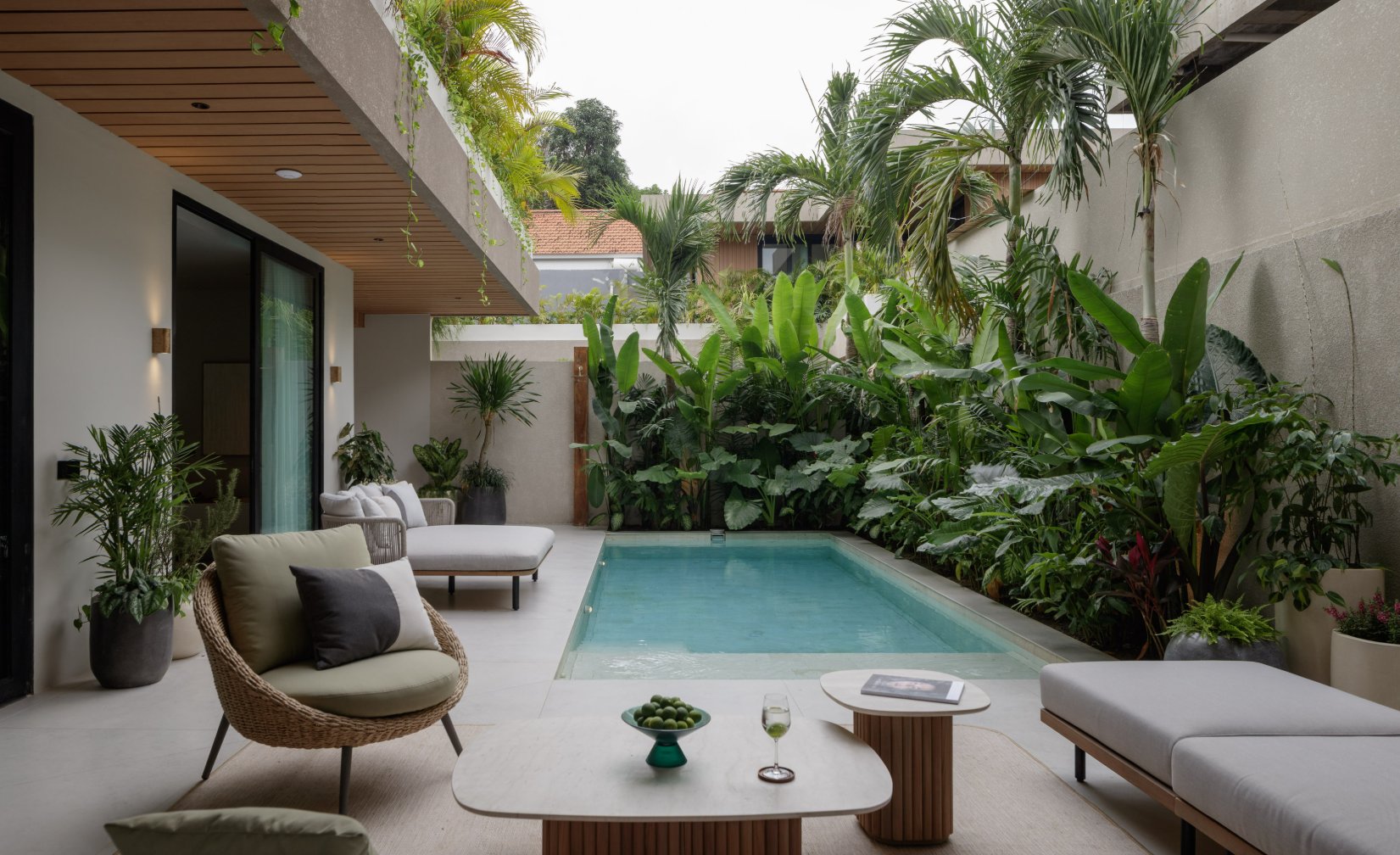 Cozy outdoor lounge area by a private pool surrounded by tropical greenery in a Canggu estate.