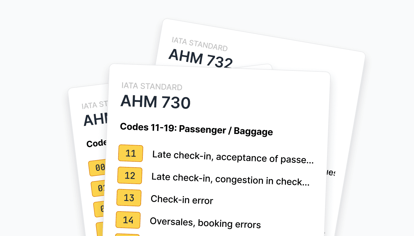 A stack of airline service code cards displays IATA standards AHM 730 and AHM 732 with details on baggage and check-in errors, highlighting standardization in aviation.