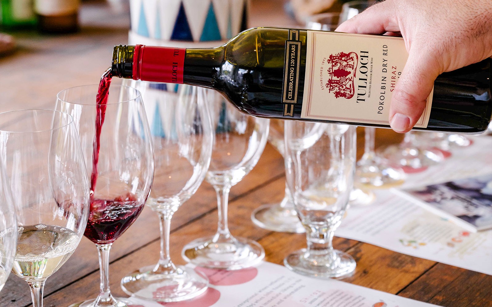 การรินไวน์แดงทัลล็อคลงในแก้วที่งานชิม Hunter Heroes