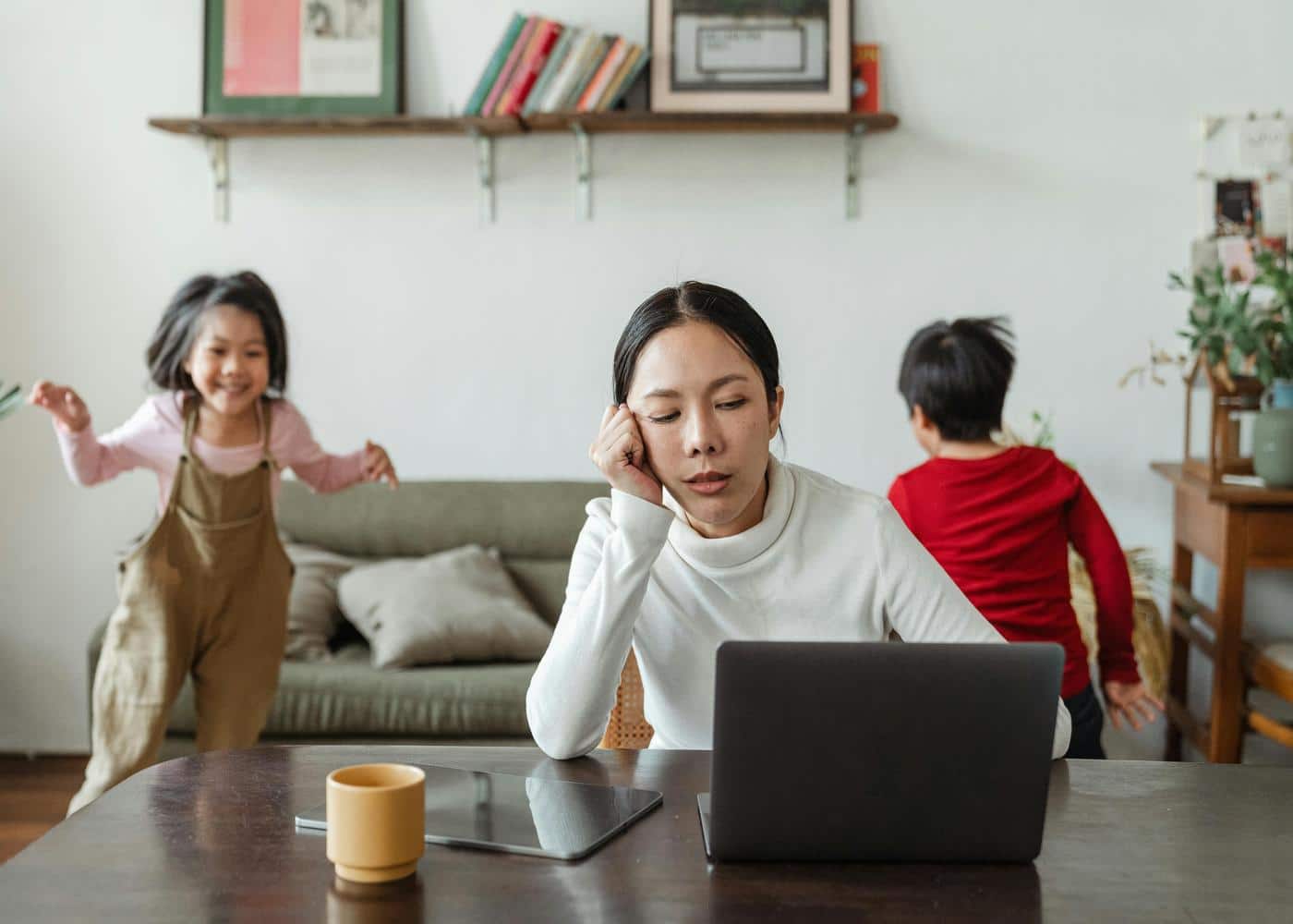Woman experiencing cognitive distraction as her kids play in the background