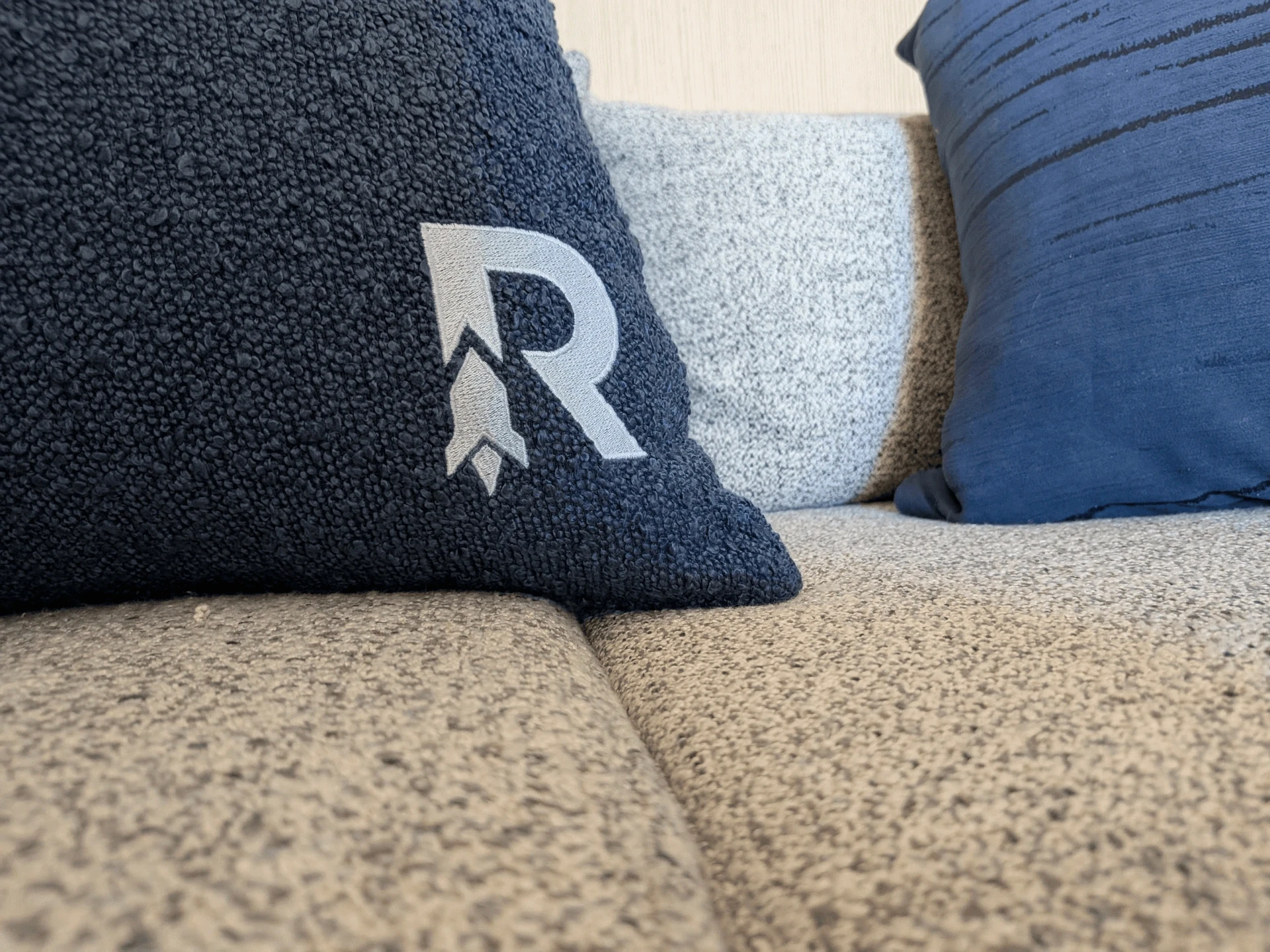 R-logo pillow on a couch