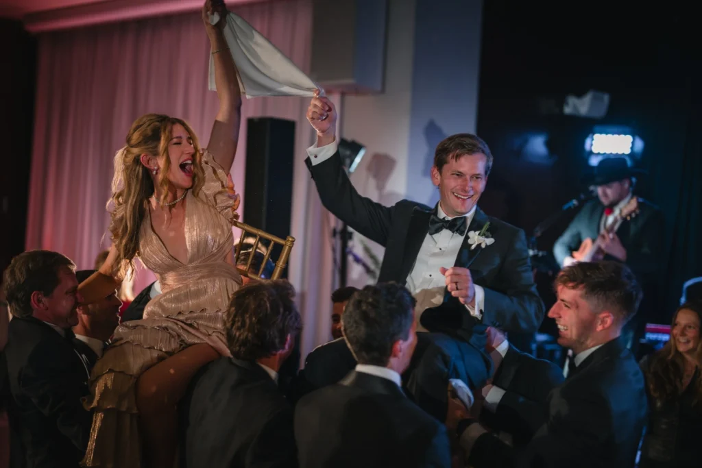 Newlyweds lifted on chairs during the reception