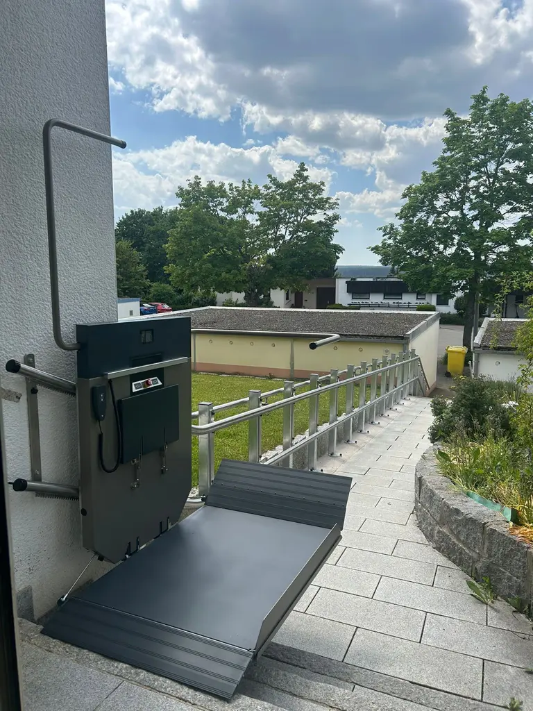 Plattformlift mit heruntergeklappter Rampe an einer Terrassentür