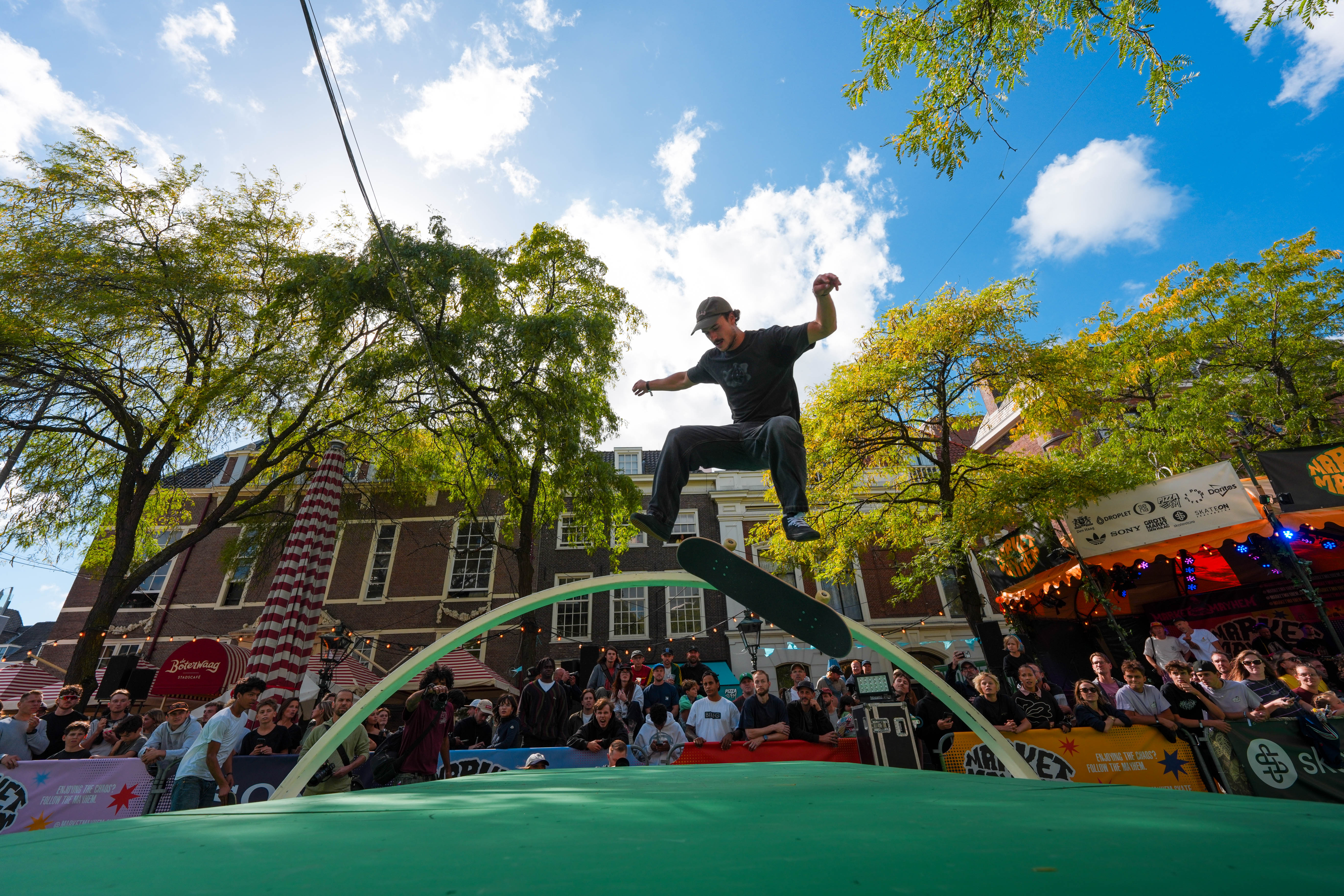 Skateboarder grinding the arch rail above the green course
