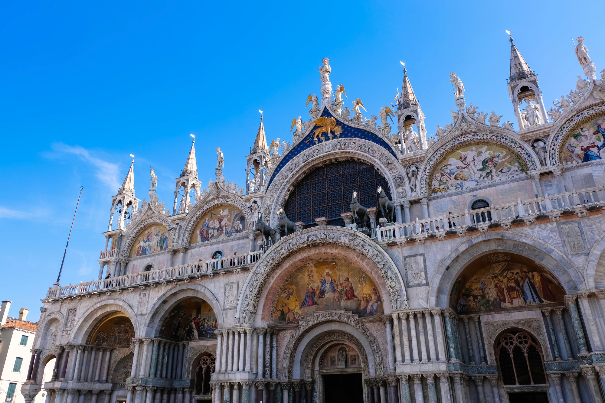 a street lined with stone buildings next to a lush green forest