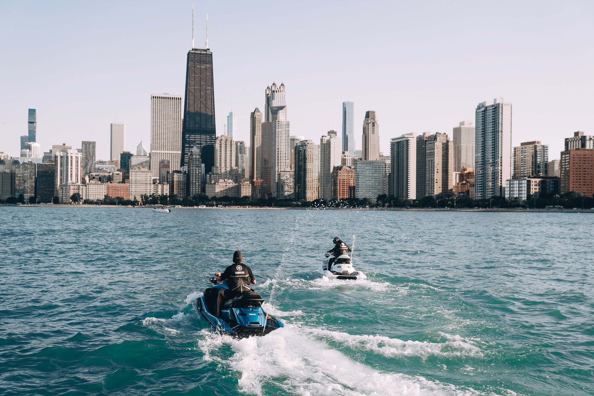 Watercraft with Chicago skyline reflected on calm water