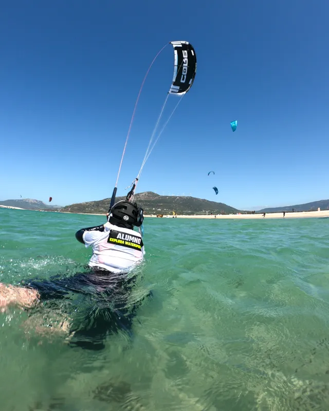 Kitesurf-Studenten üben das Body-Dragging im Wasser unter Aufsicht bei Explora Watersports Tarifa