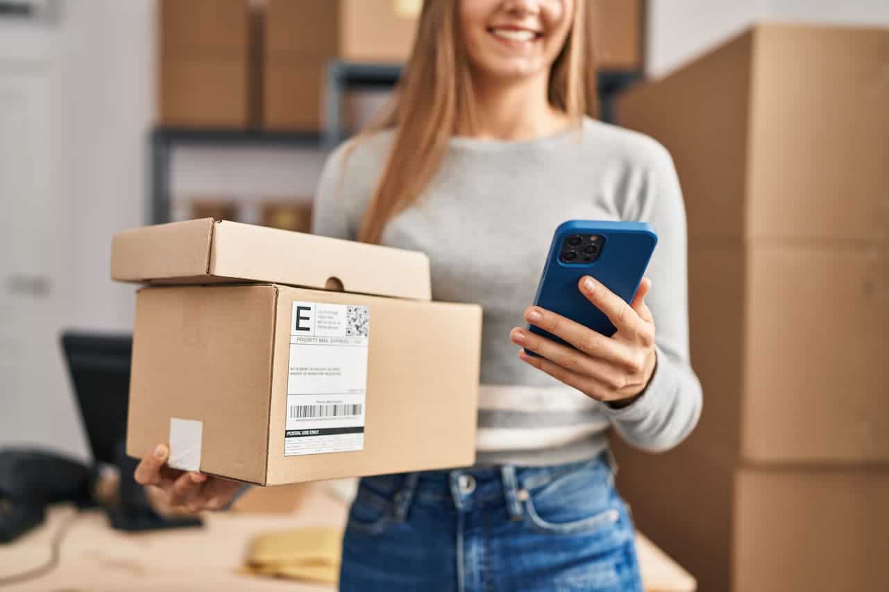Ragazza che usa il telefono per tracciare il suo pacco in consegna