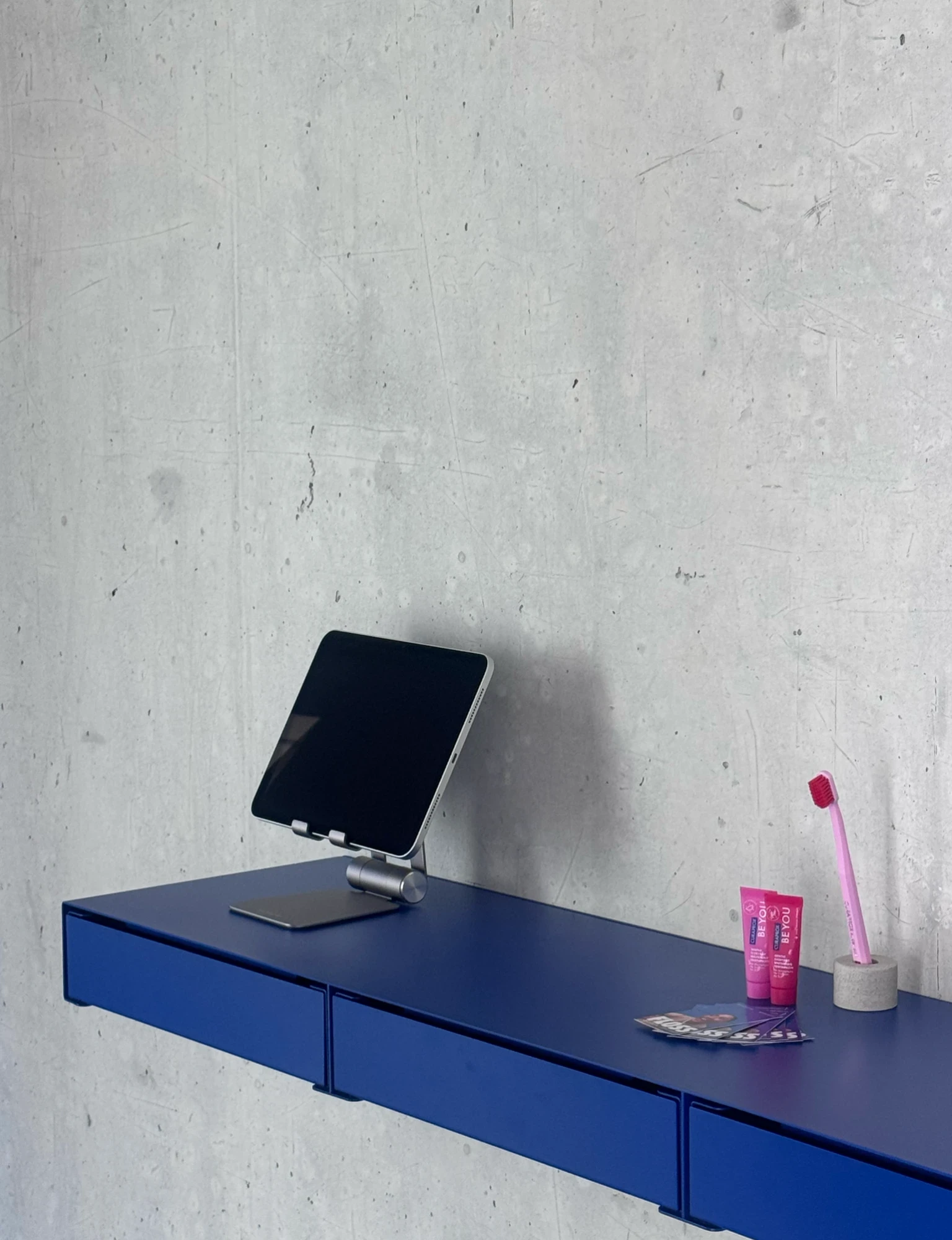 Blaues Regal mit Tablet und Zahnpflegeprodukten im FLOSS Studio