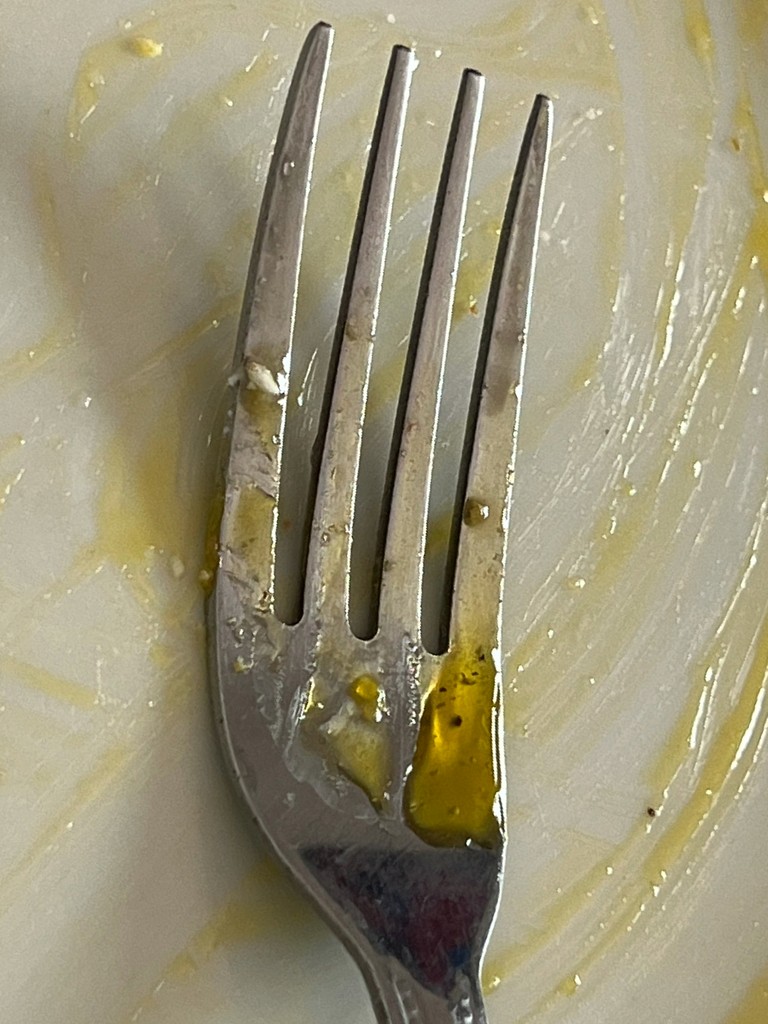 "Fork with egg residue on a plate"