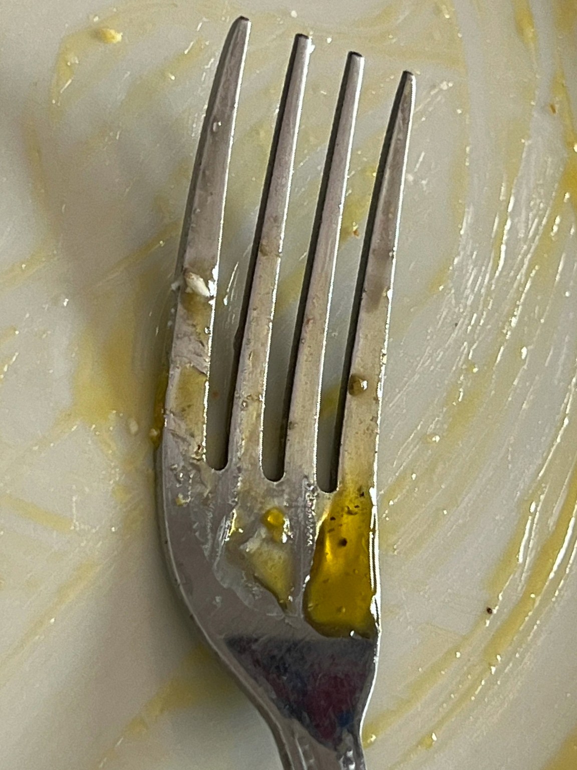 "Fork with egg residue on a plate"