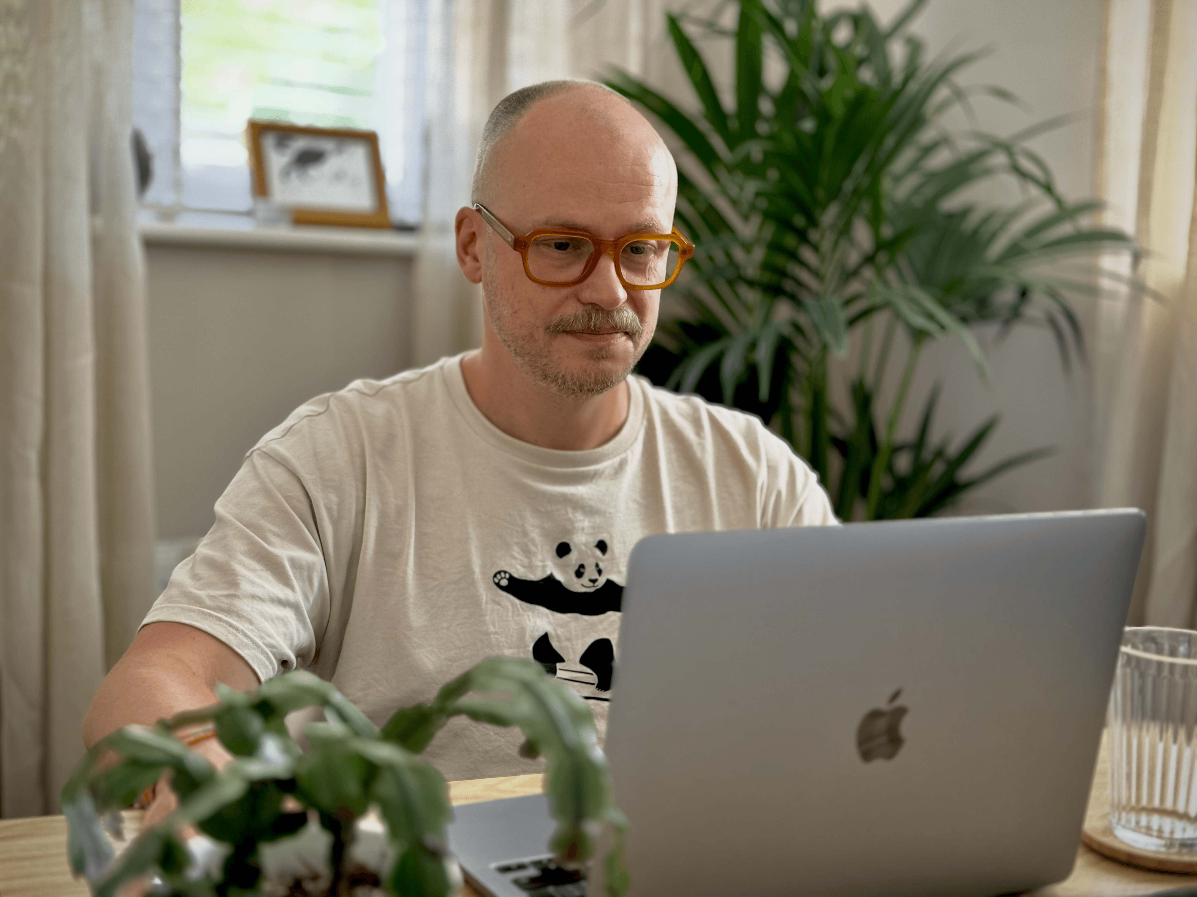 A photo of Justin in his therapy room, sitting at a desk on an online client session.