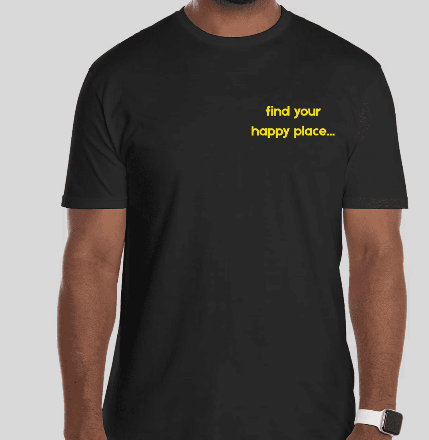 Black t-shirt with yellow text 'find your happy place...' worn by a person on a light gray background