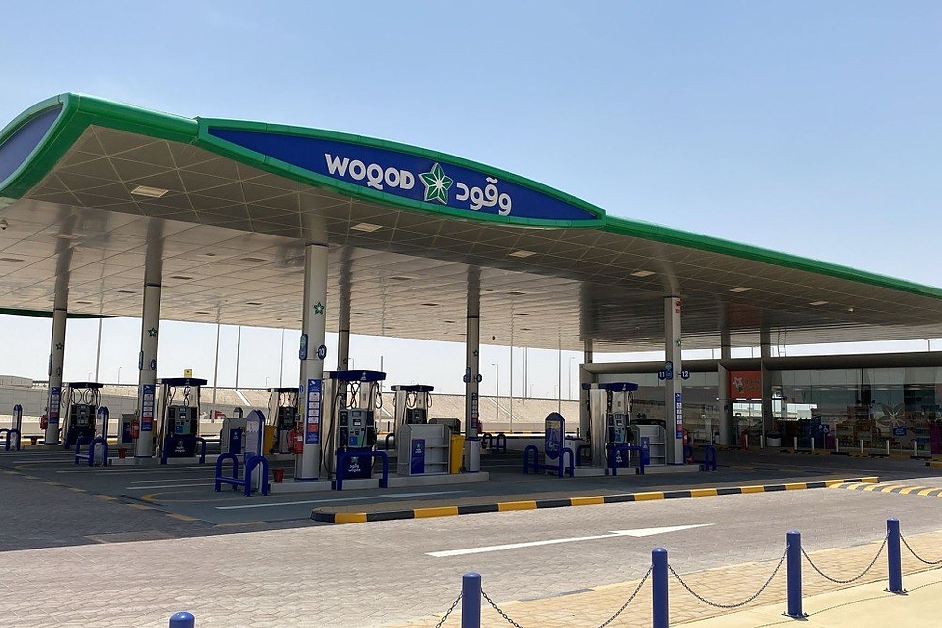 La station Woqod d'Al Nigyan, au Qatar, avec son auvent vert et bleu et ses pompes : dans le réseau Woqod, on fait aussi la vidange, les pneus et les freins