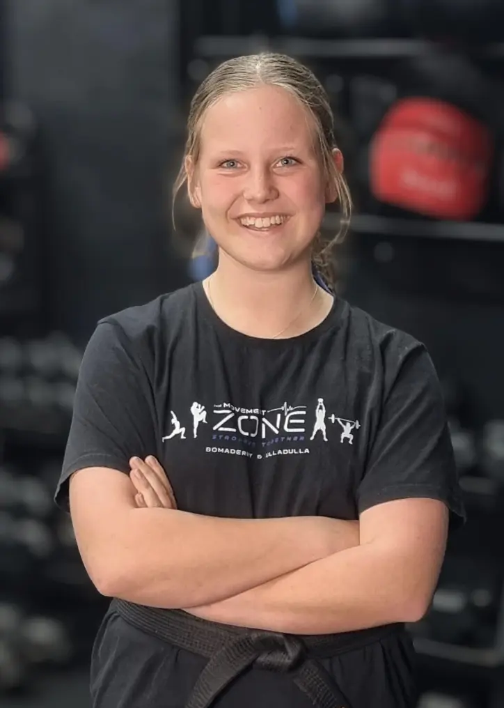 Coach Anto Newton posing in The Movement Zone shirt inside the training facility.