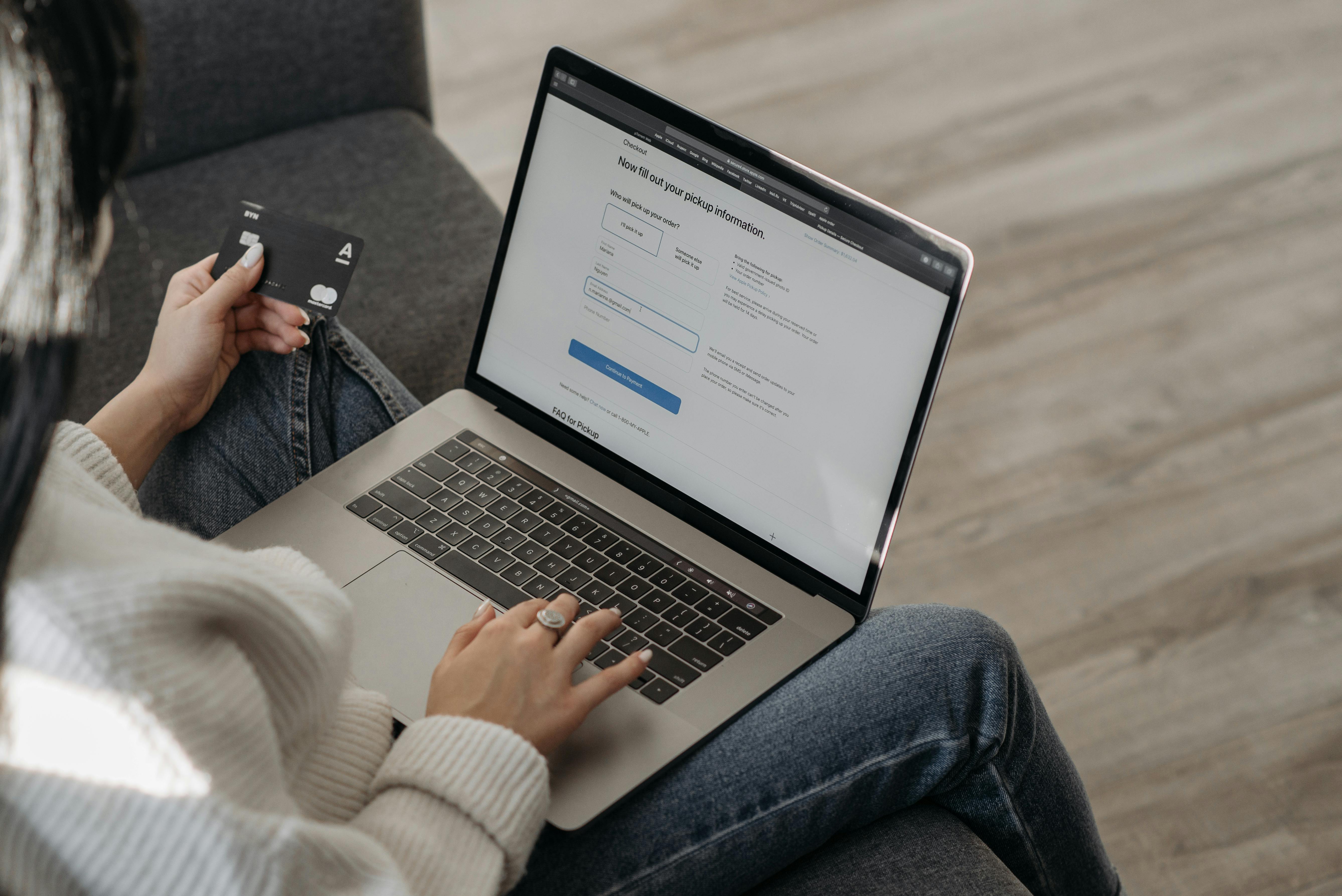 man sitting facing silver MacBook inside room